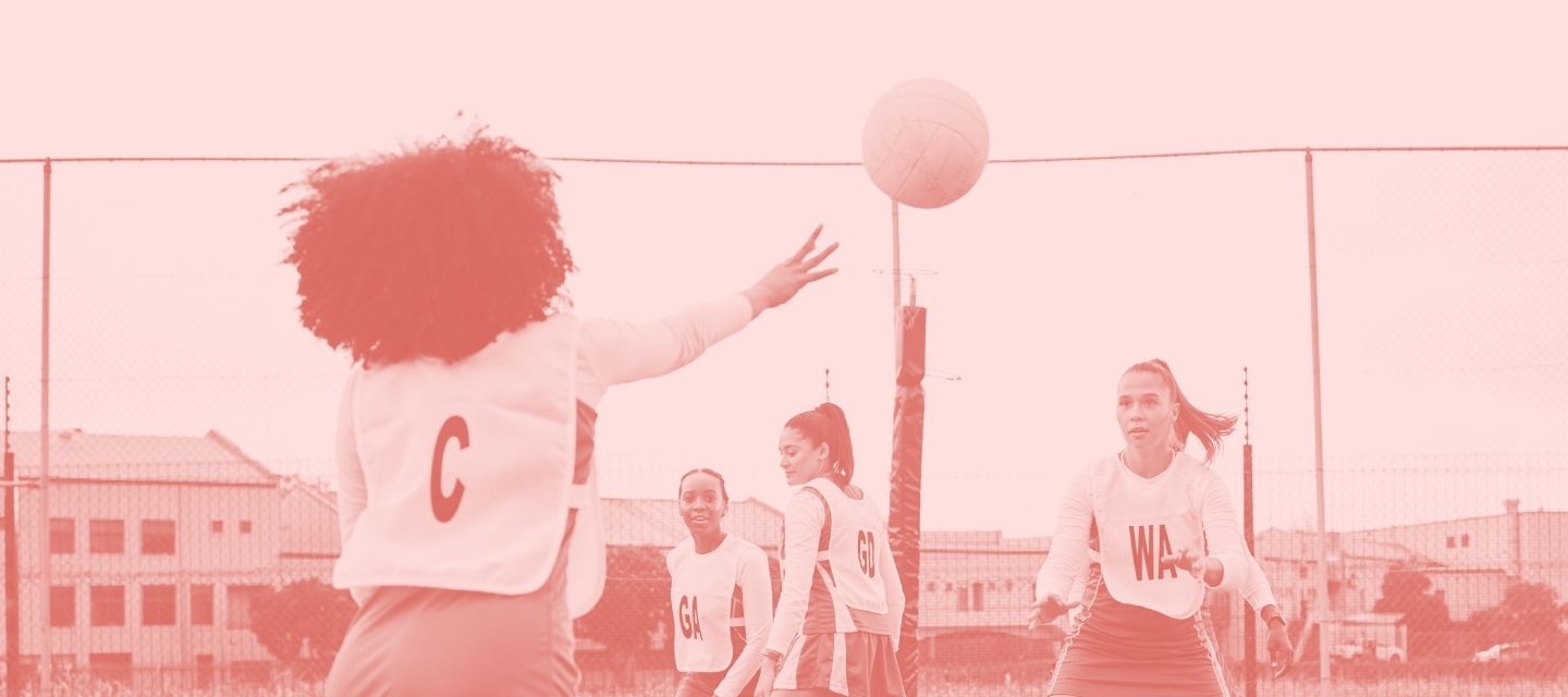 Netballers mid-play wearing reused kit from kitround.