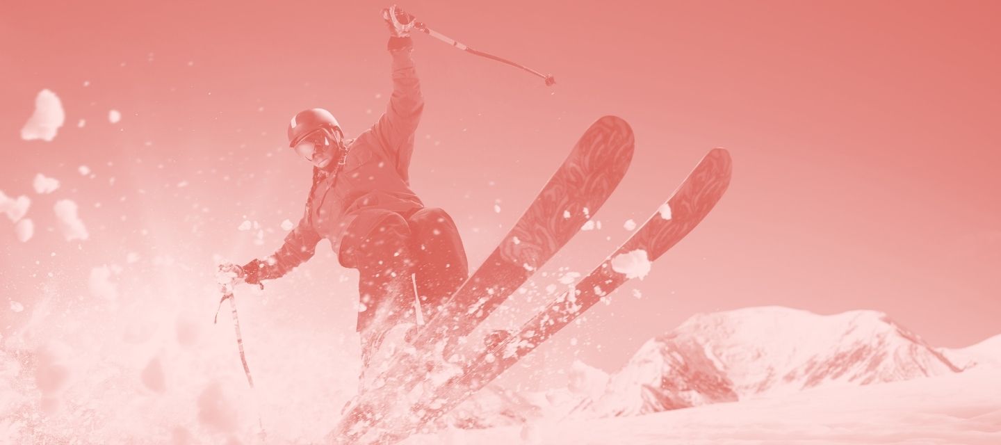 Skier carving downhill wearing reused skiwear from kitround.