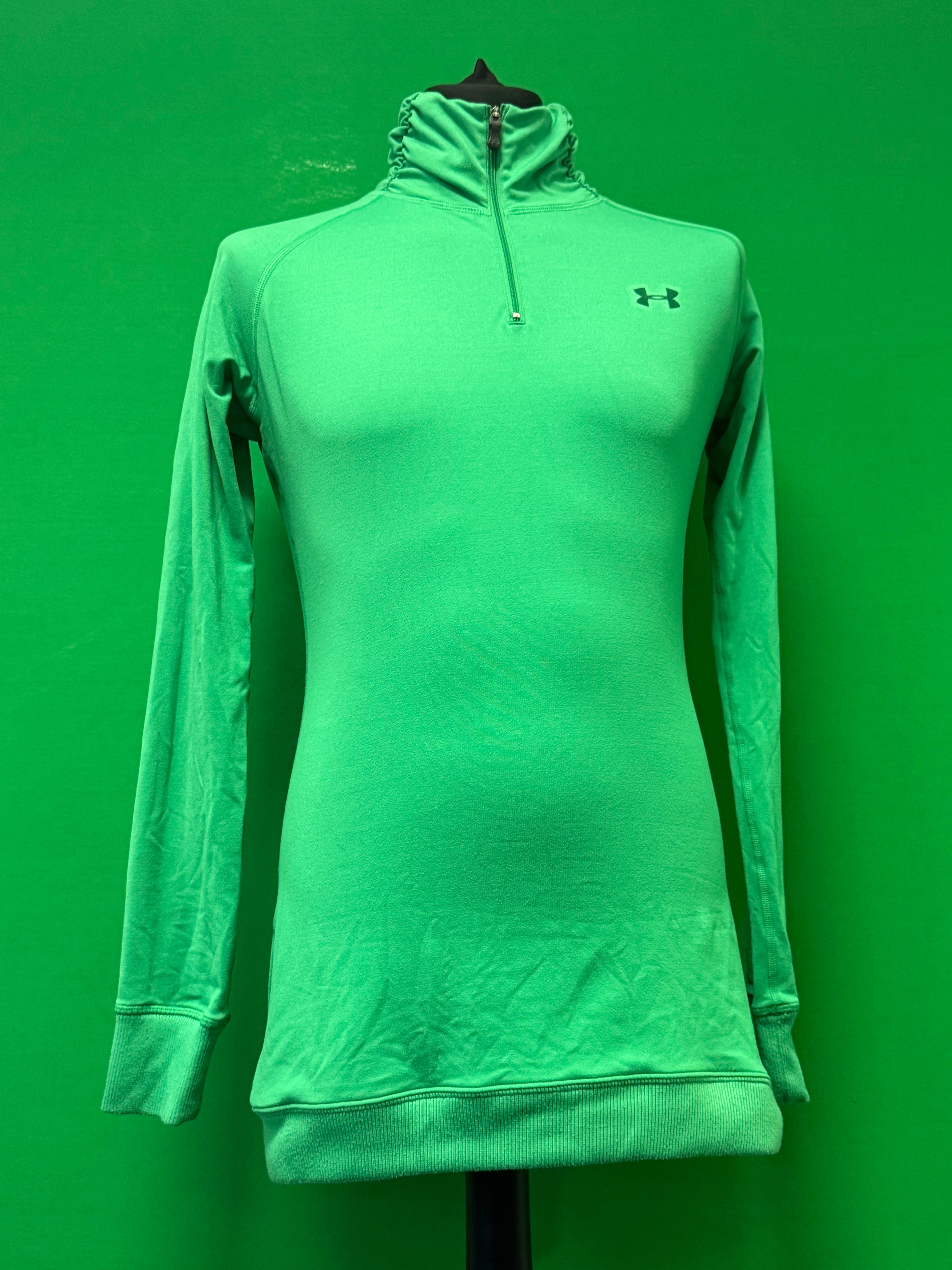 Vibrant green Under Armour 1/4 zip top with long sleeves displayed on a mannequin against a green background