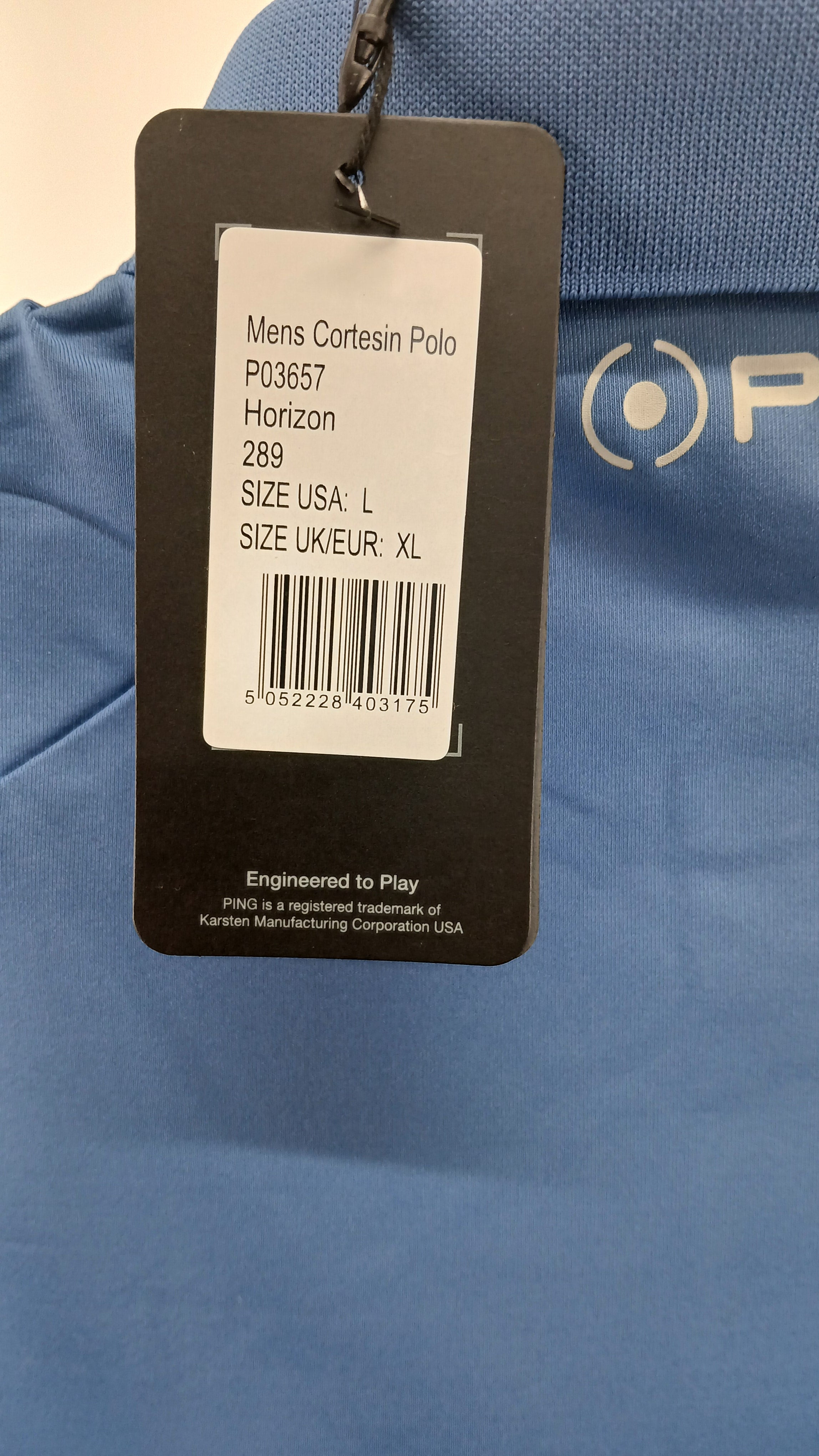 Close-up of product tag for Ping Solheim Cup 2023 men's golf polo shirt with size and model details