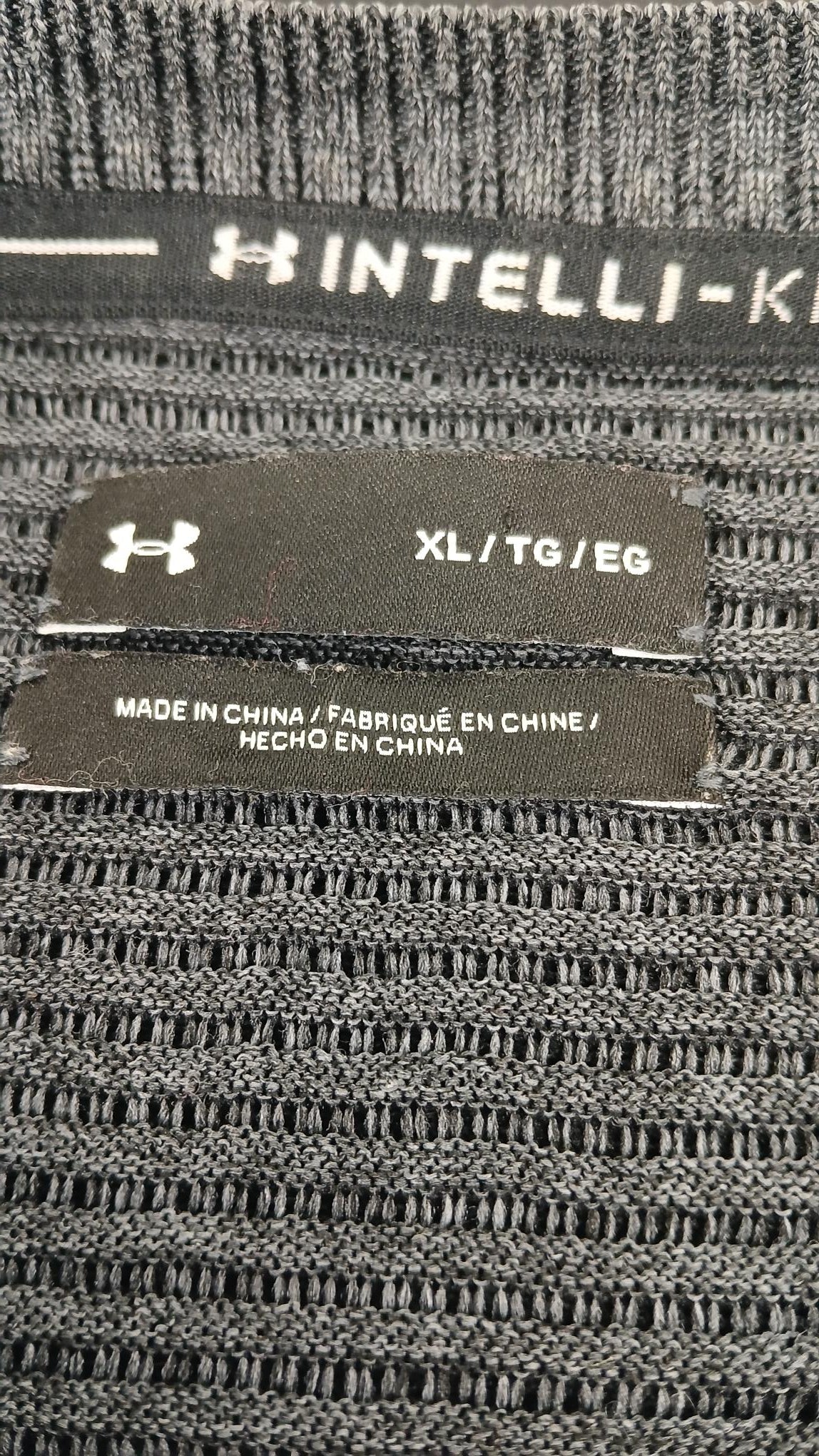 Close-up of Under Armour jumper label showing size XL and intelli-knit fabric detail