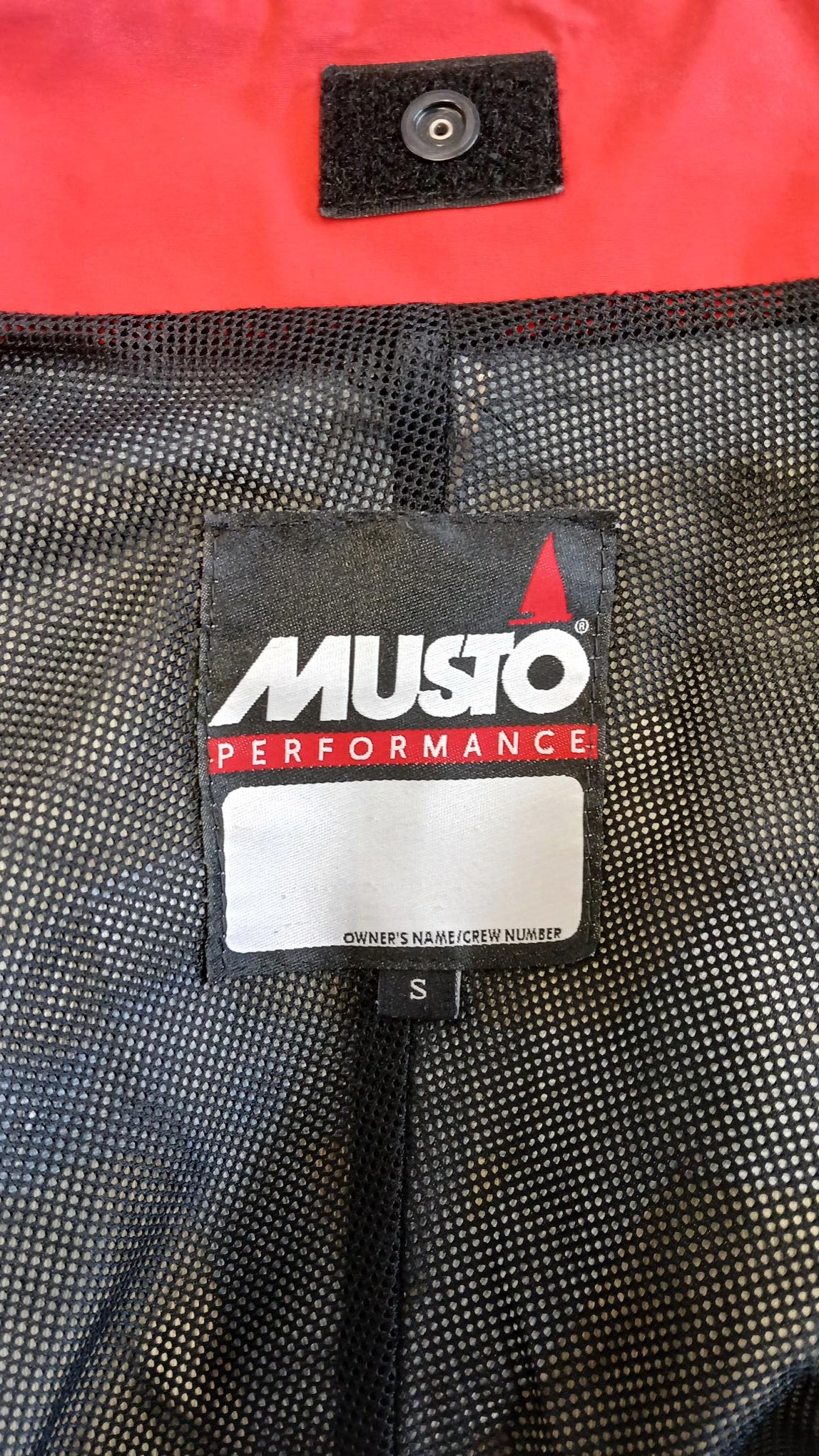 Close-up of Musto Performance label inside the mesh lining of the sailing jacket