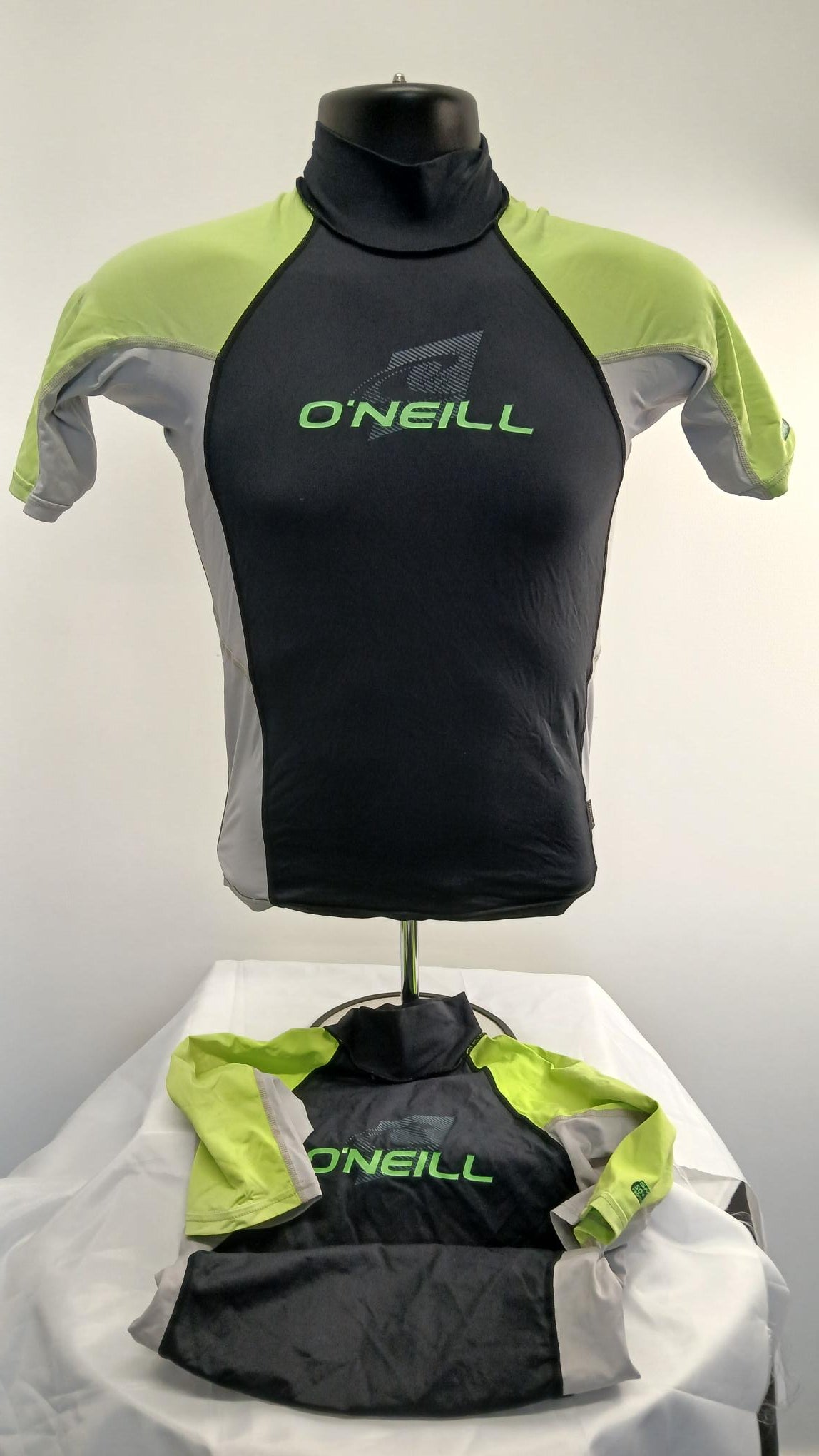 Front view of O'Neill women's short sleeve rash vest in black with lime green and grey panels