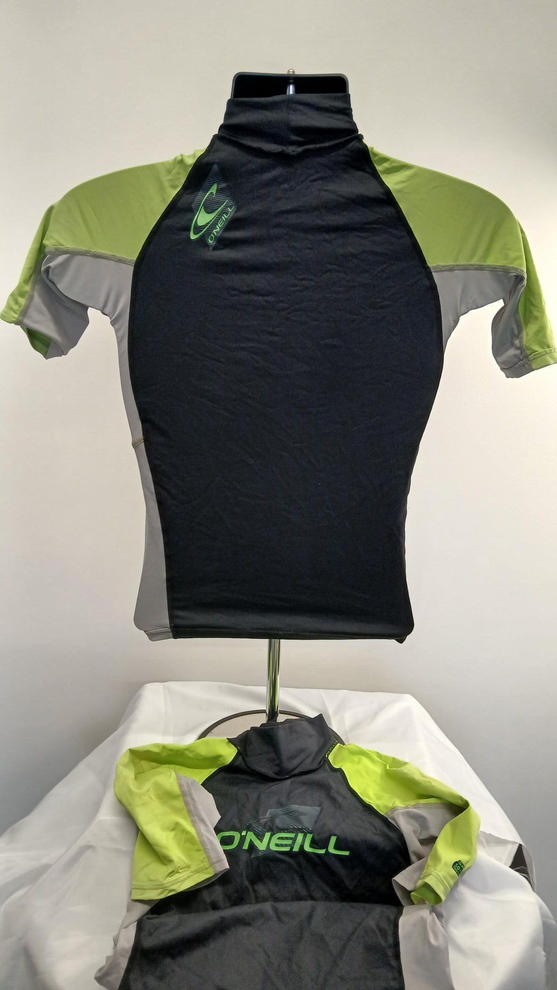 Back view of O'Neill women's rash vest showing black back with lime green and grey sleeves
