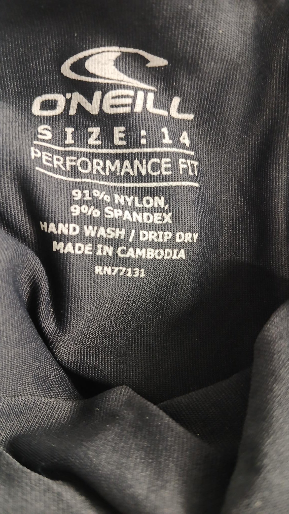 Close-up of O'Neill rash vest label showing size 14, material 91% nylon and 9% spandex