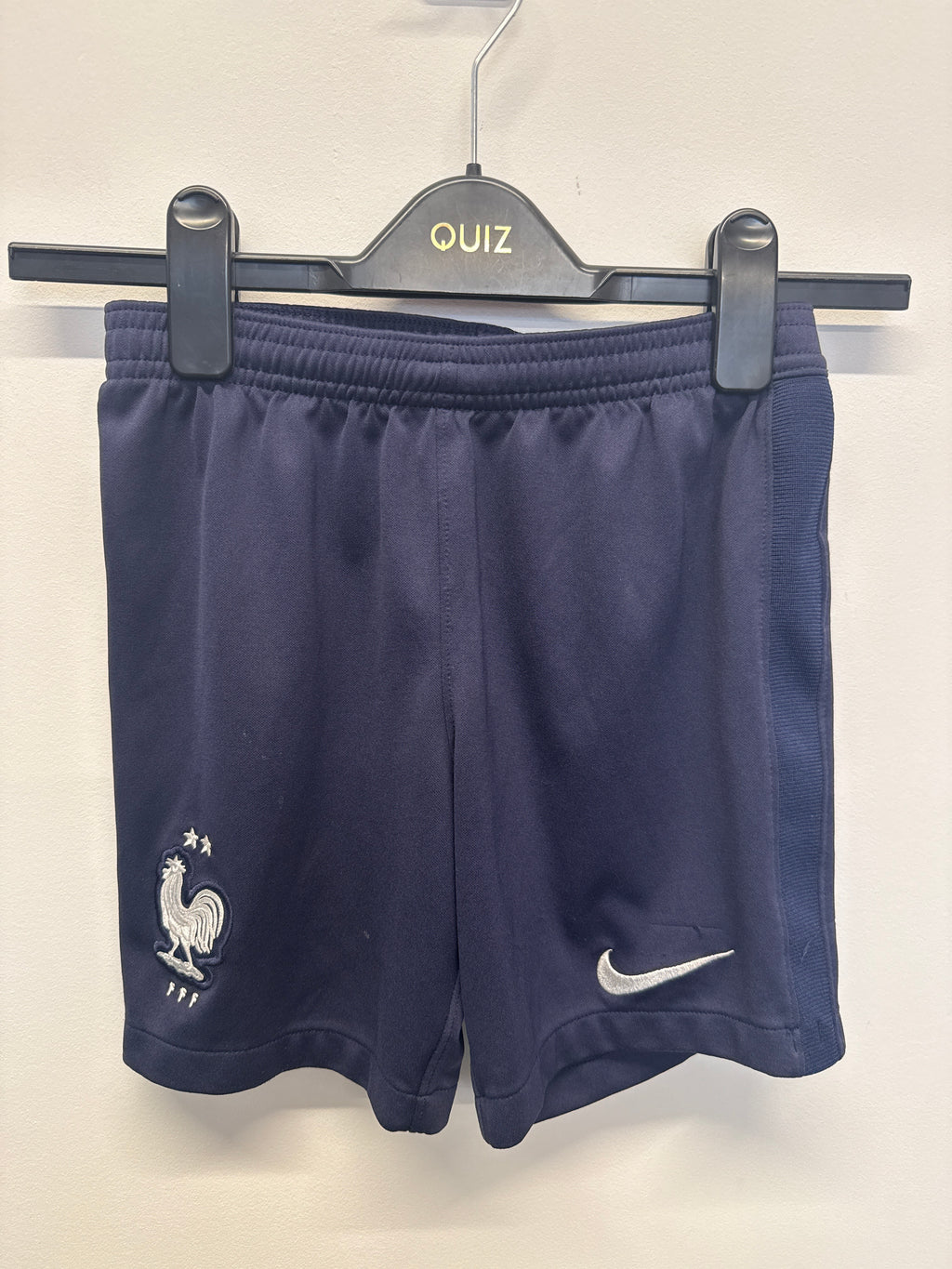 Navy blue Nike France kids' football shorts on hanger with FFF crest and Nike Swoosh