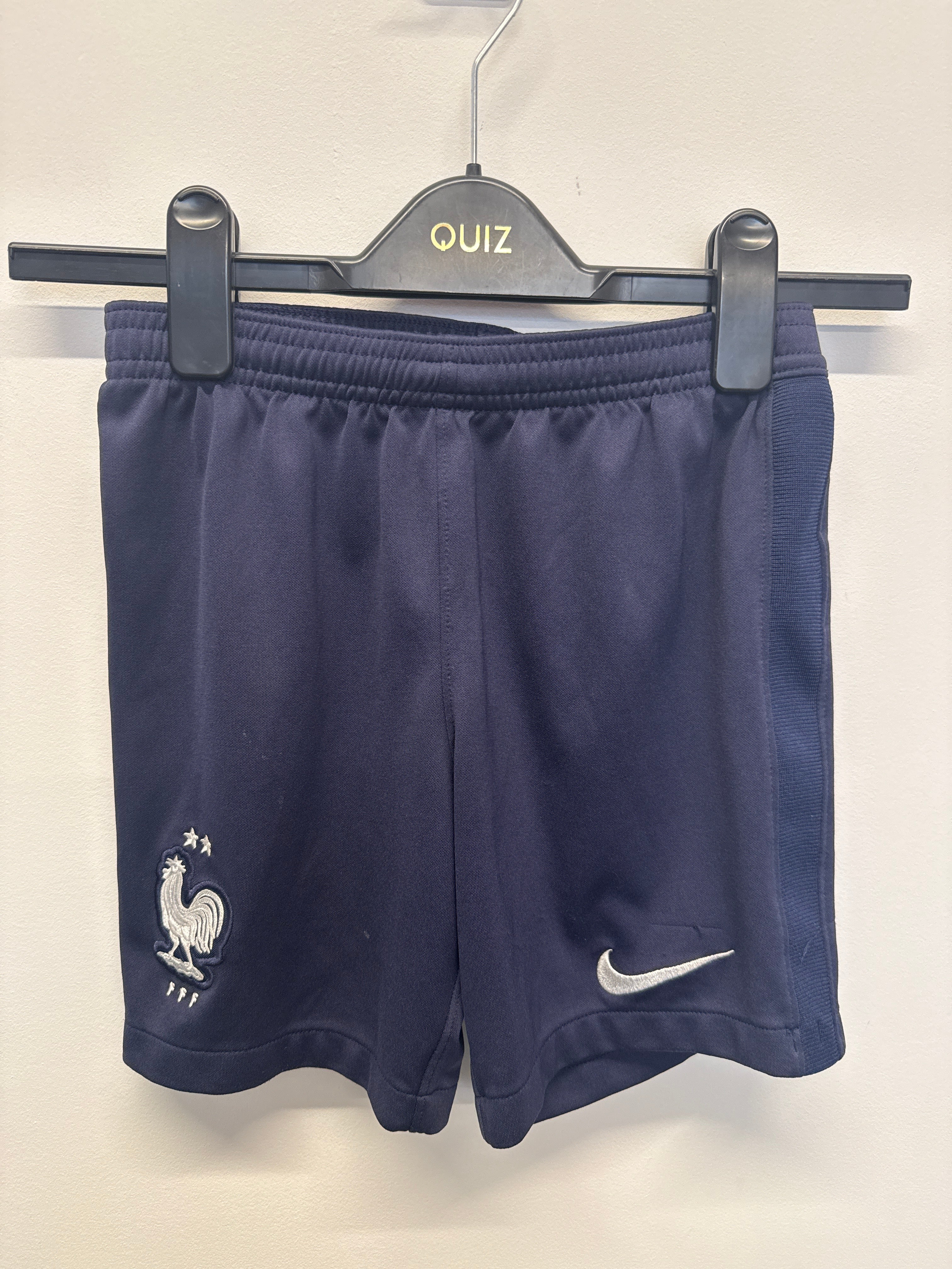 Navy blue Nike France kids' football shorts on hanger with FFF crest and Nike Swoosh