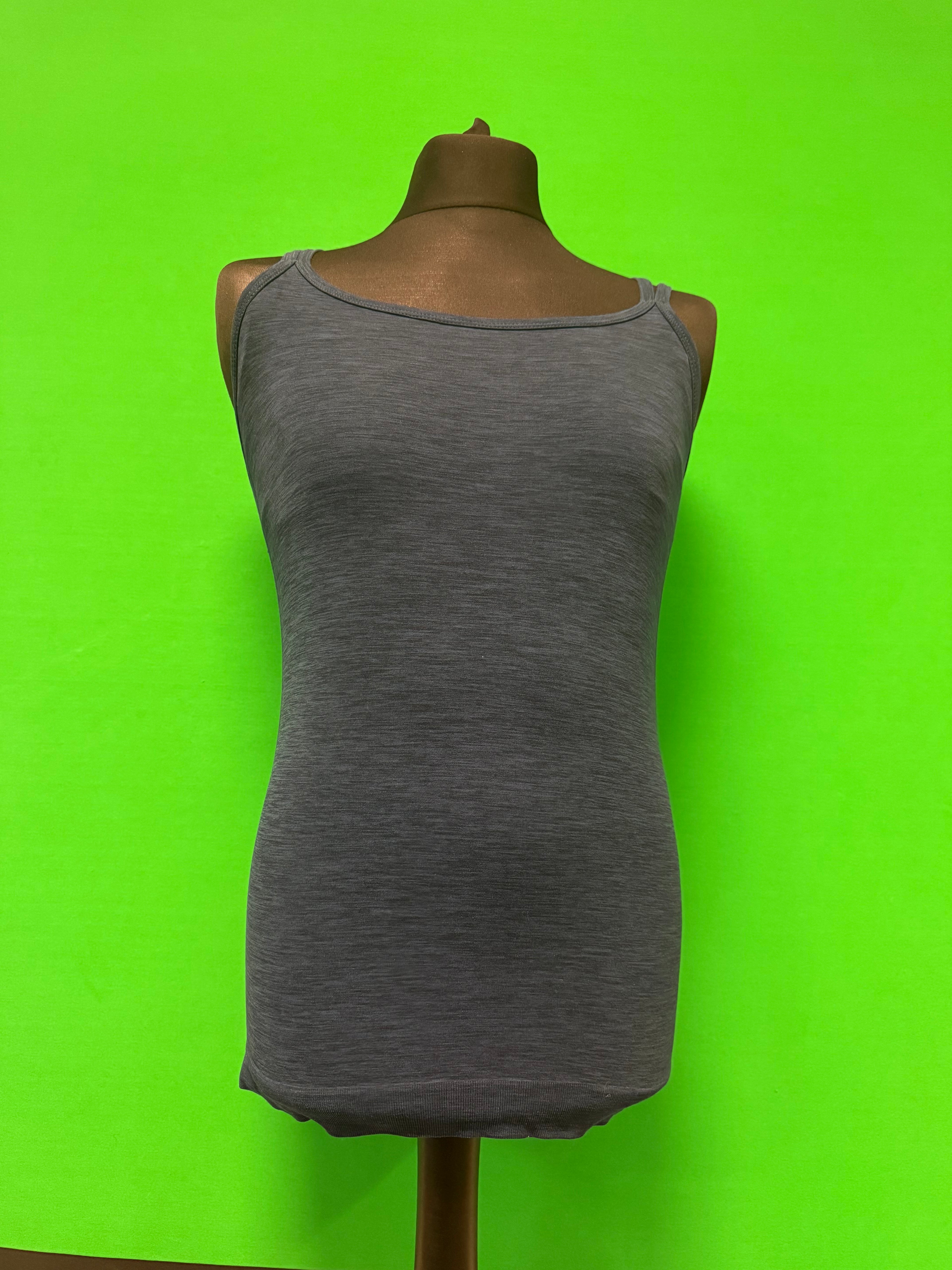 Front view of grey women's activewear tank top with thin straps on mannequin against bright green background