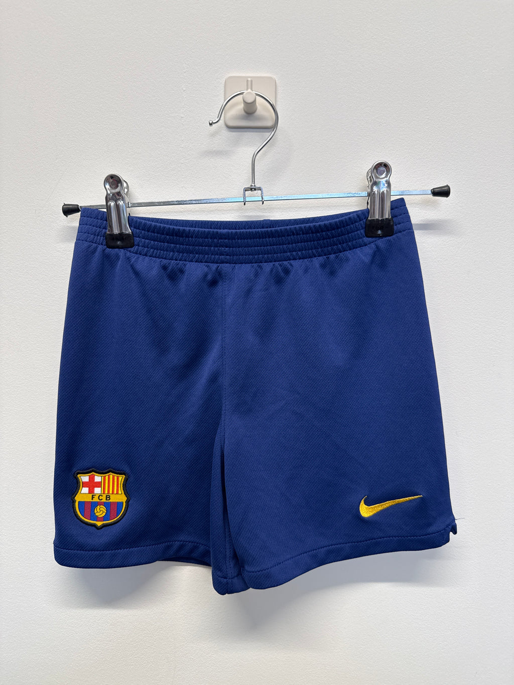Front view of blue Barcelona kids' football shorts with Nike logo and club crest