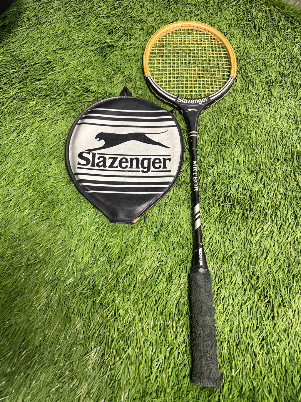 Vintage Slazenger Meteor badminton racquet with original cover on grass