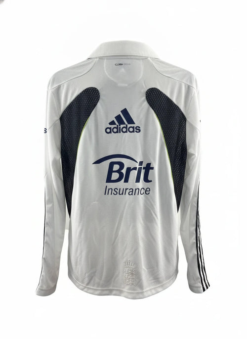 The back of an adidas England Cricket Long Sleeve Jersey in white with blue and black accents, featuring the adidas logo and "Brit Insurance" branding.