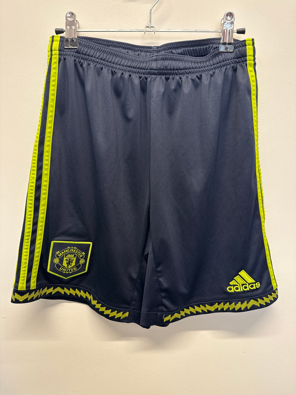 Front view of Manchester United adidas youth football shorts with club badge and yellow accents