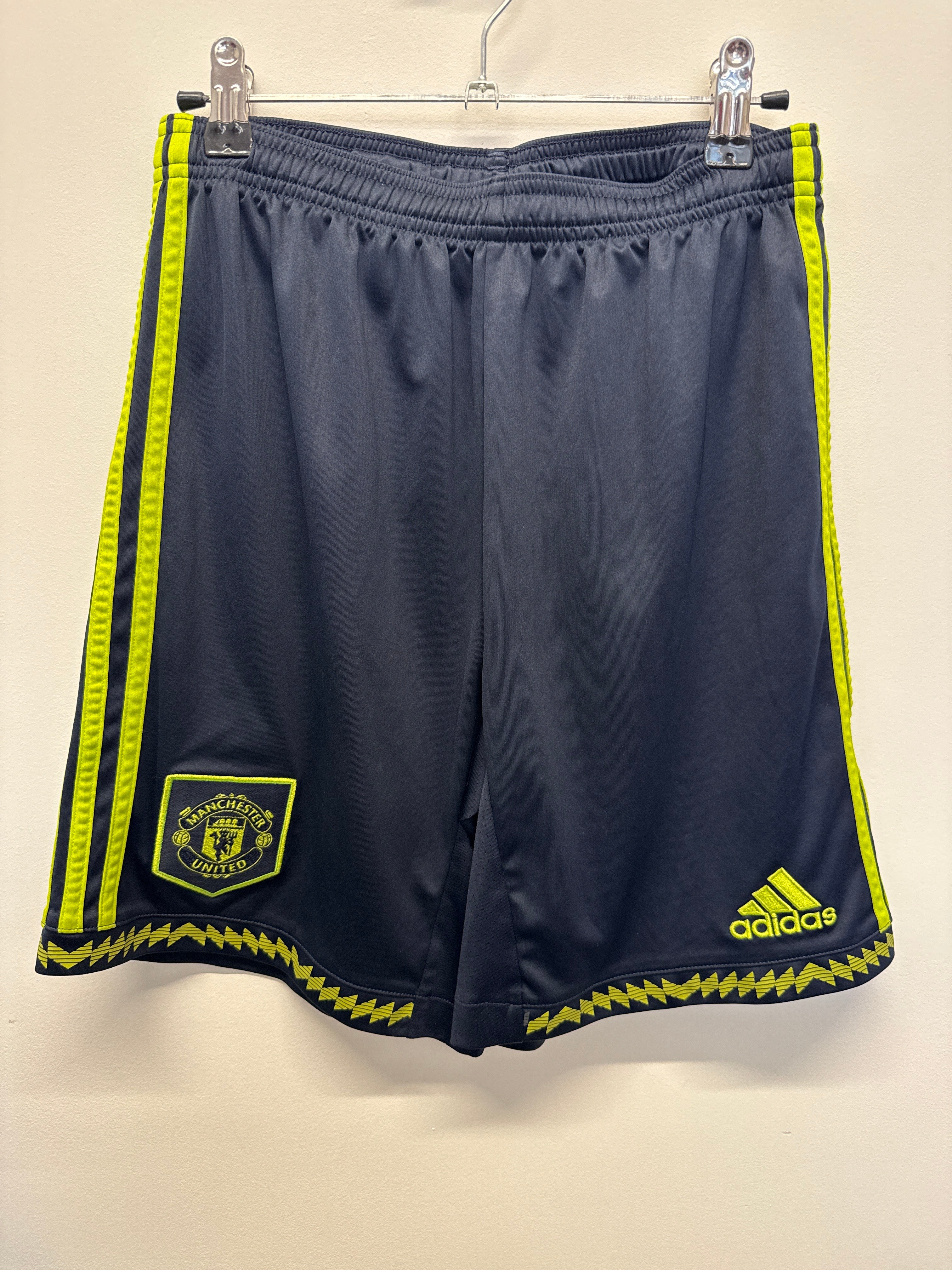 Front view of Manchester United adidas youth football shorts with club badge and yellow accents