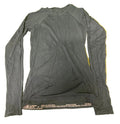Dark charcoal long sleeve Sweaty Betty top laid flat on green turf