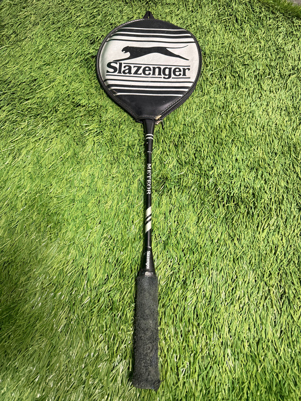 Vintage Slazenger Meteor badminton racquet covered with protective case on grass