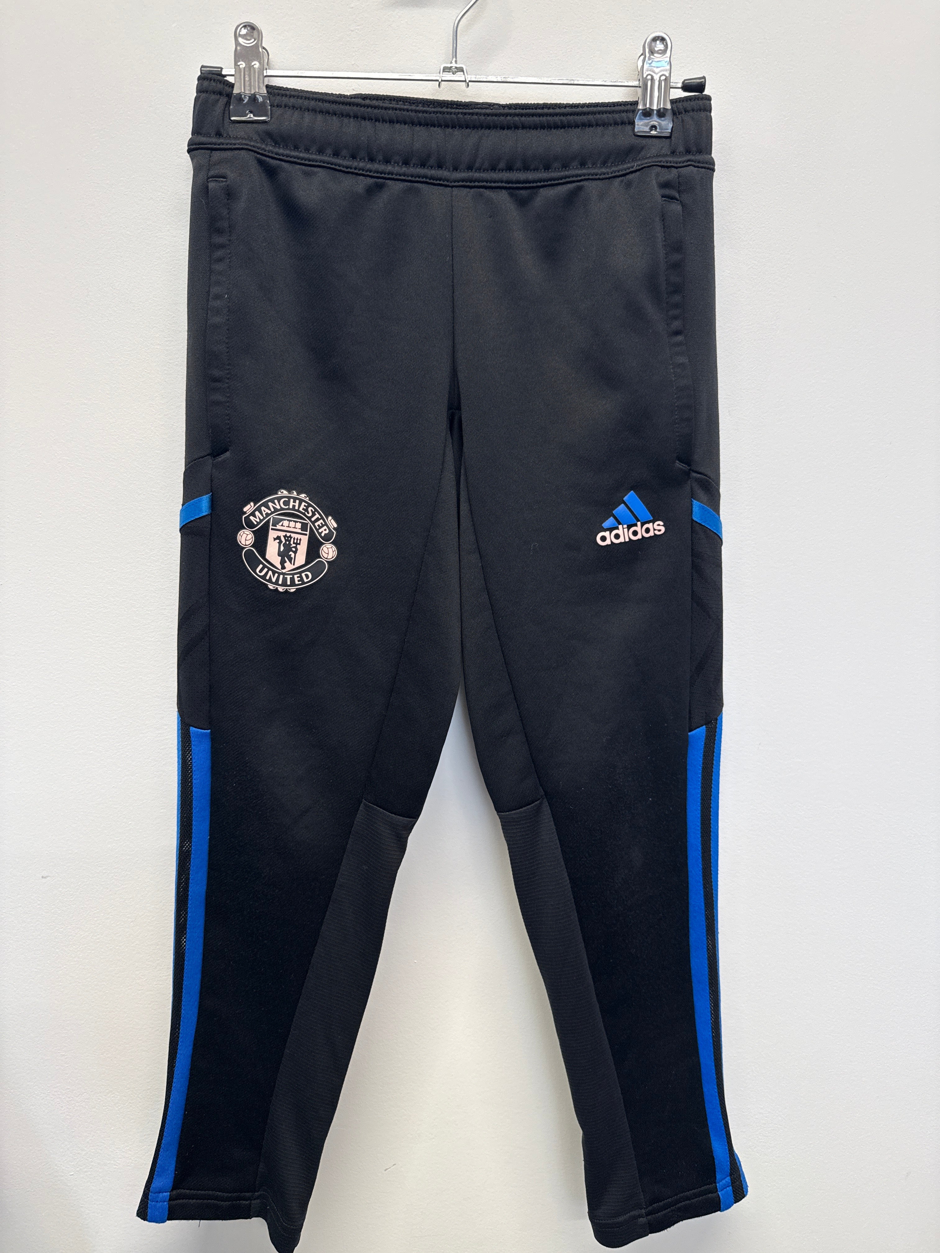 Front view of Manchester United adidas kids' black training pants with blue stripes and embroidered logos