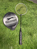 Slazenger graphite reinforced badminton racquet with cover on grass