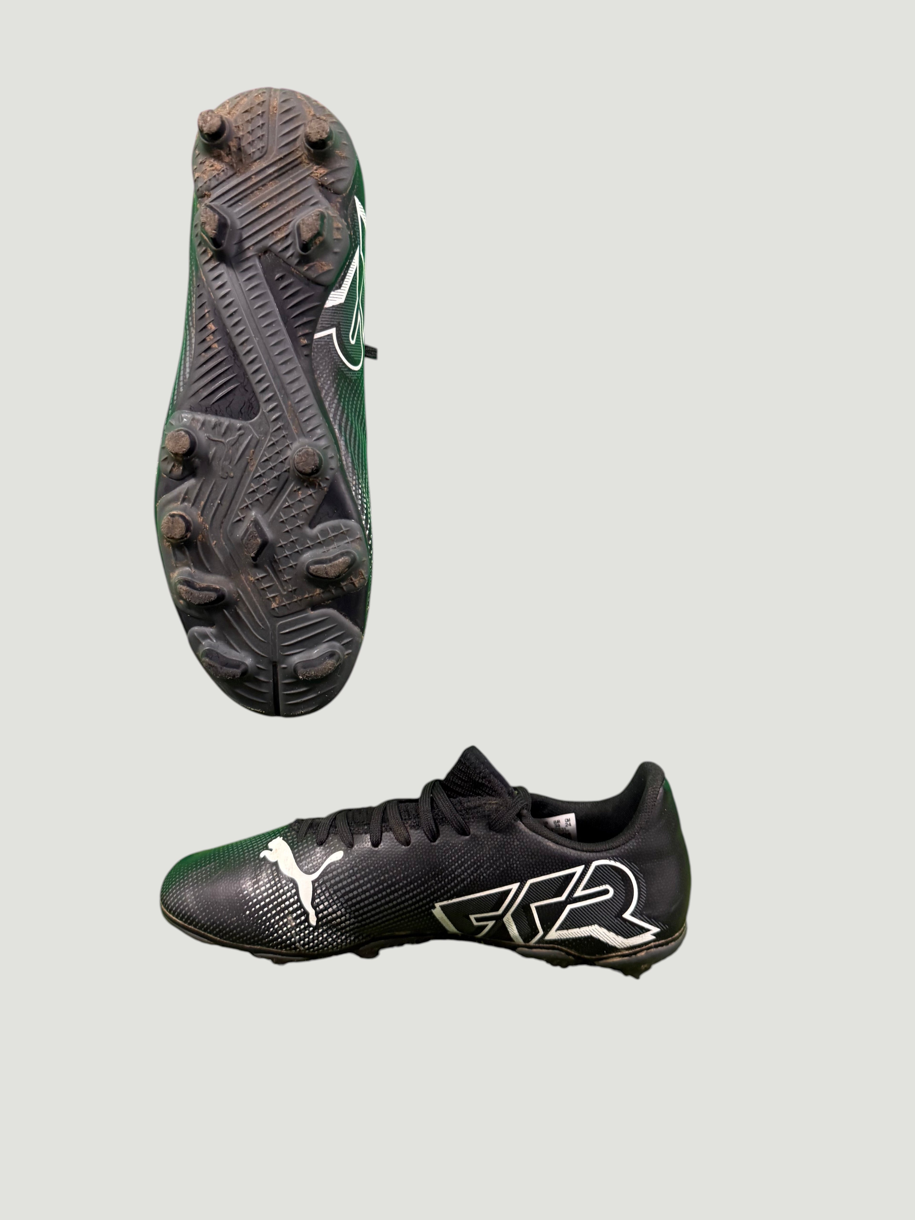 Opposite side and studded sole of black Puma football boot featuring GRR branding