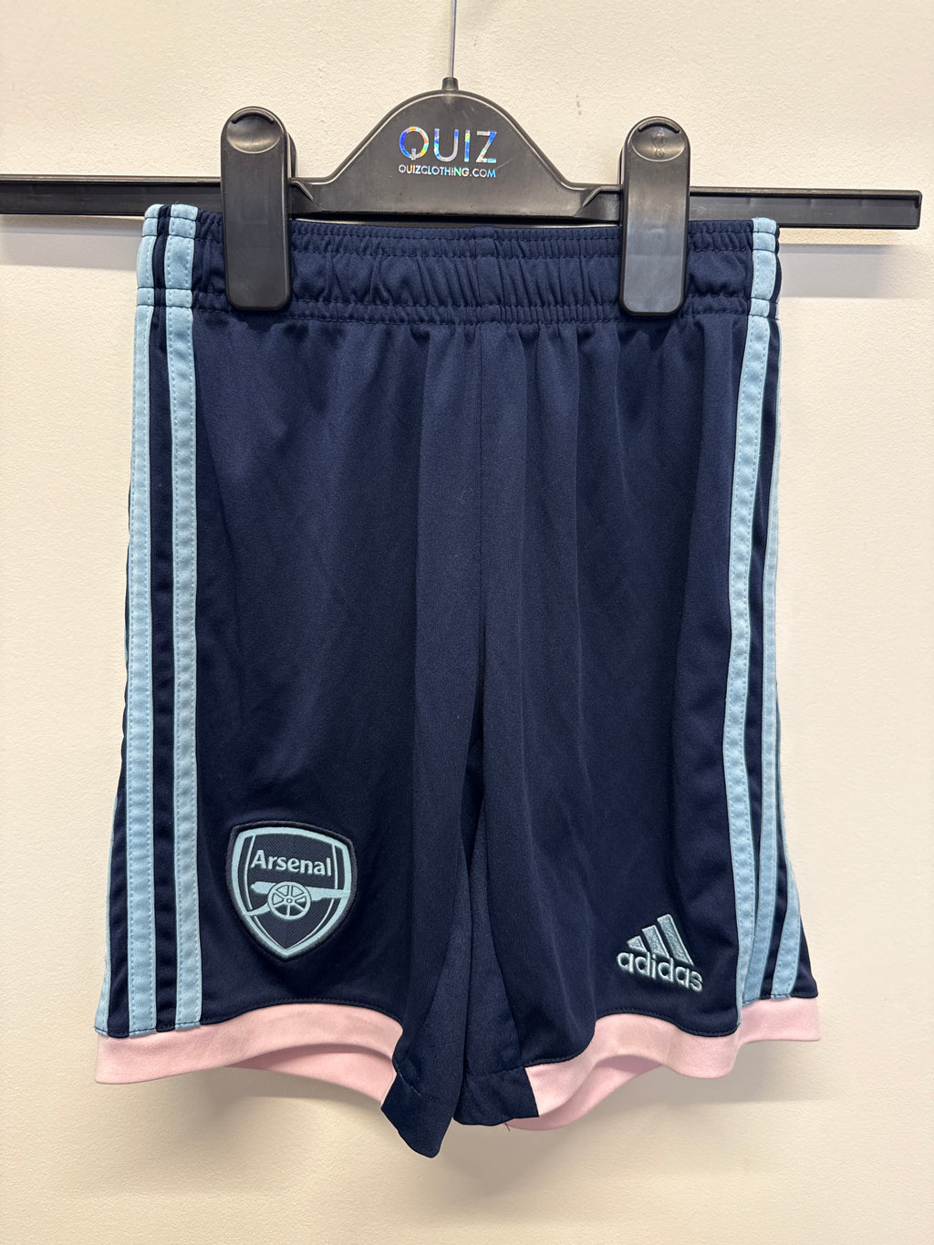 Front view of navy blue Arsenal kids' football shorts by adidas with light blue stripes and pink trim