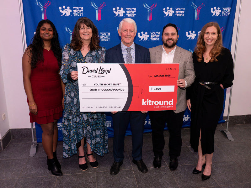 A group of five people hold a cheque from kitround to the Youth Sport Trust