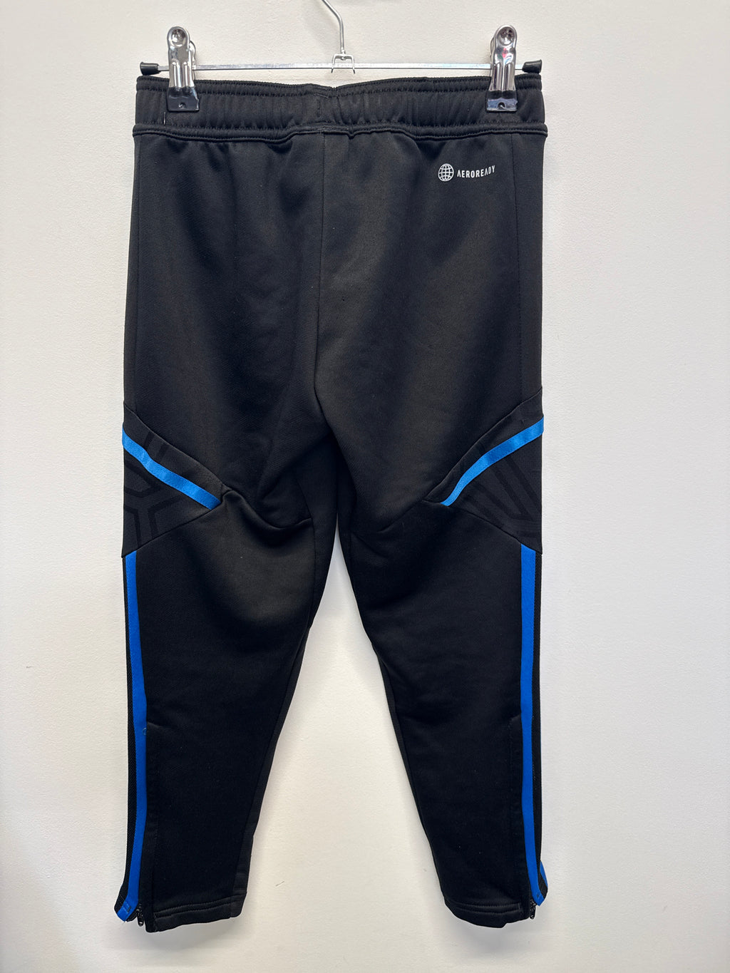 Back view of Manchester United adidas kids' black training pants with blue stripe details