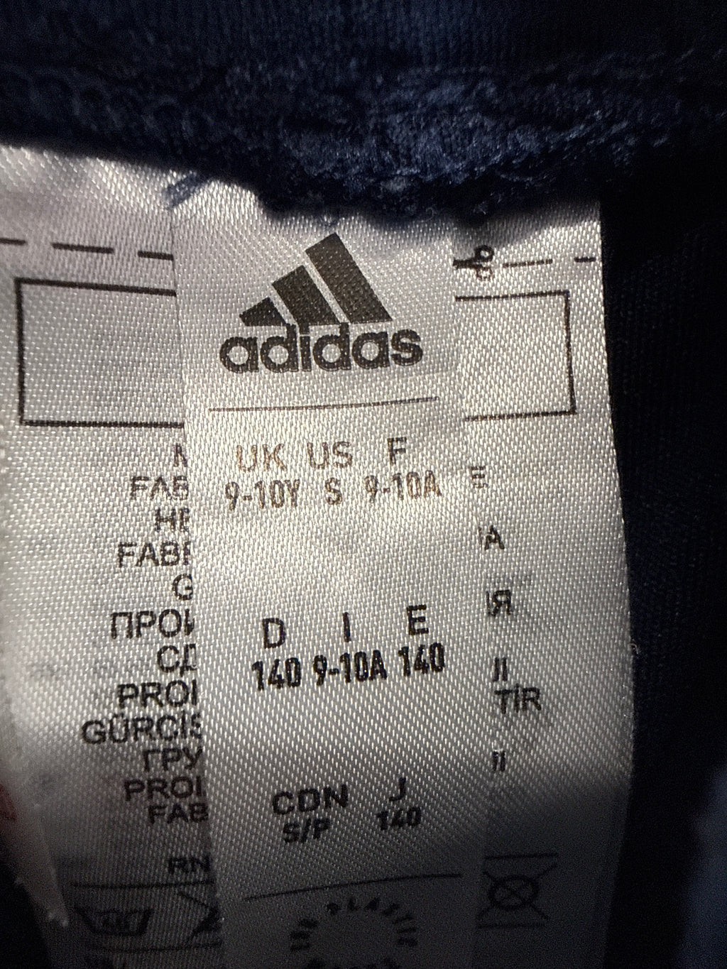 Close-up of adidas size and care label inside the Arsenal kids' football shorts