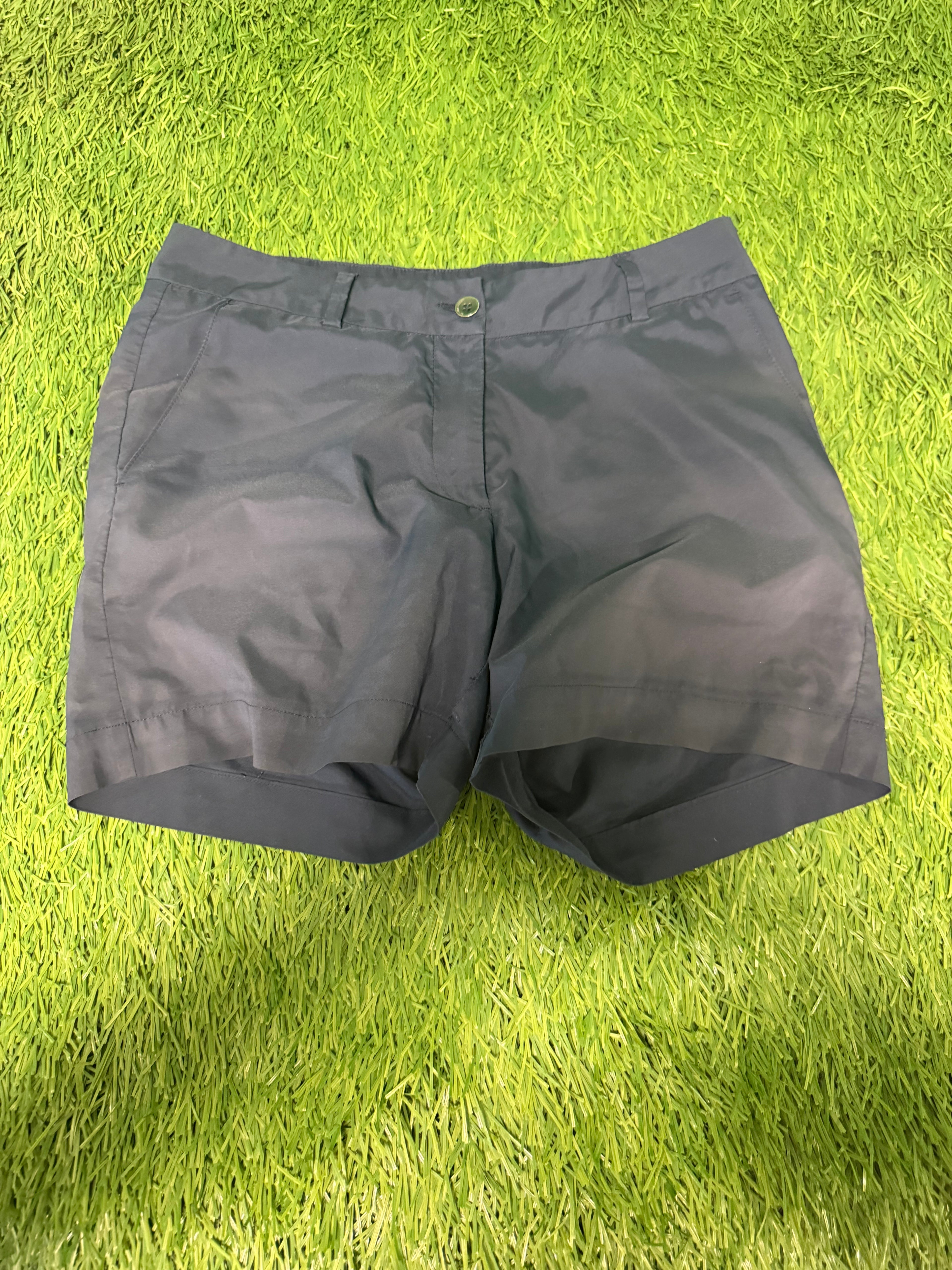 Front view of black Galvin Green golf shorts on green grass