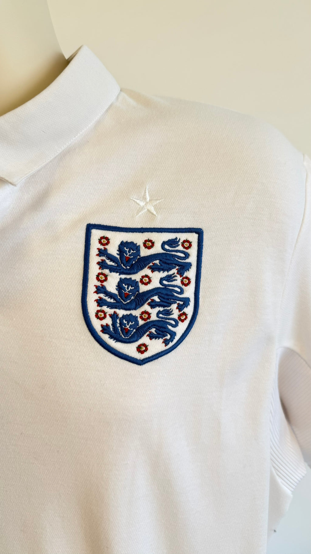 Close-up of three lions crest and star on England shirt