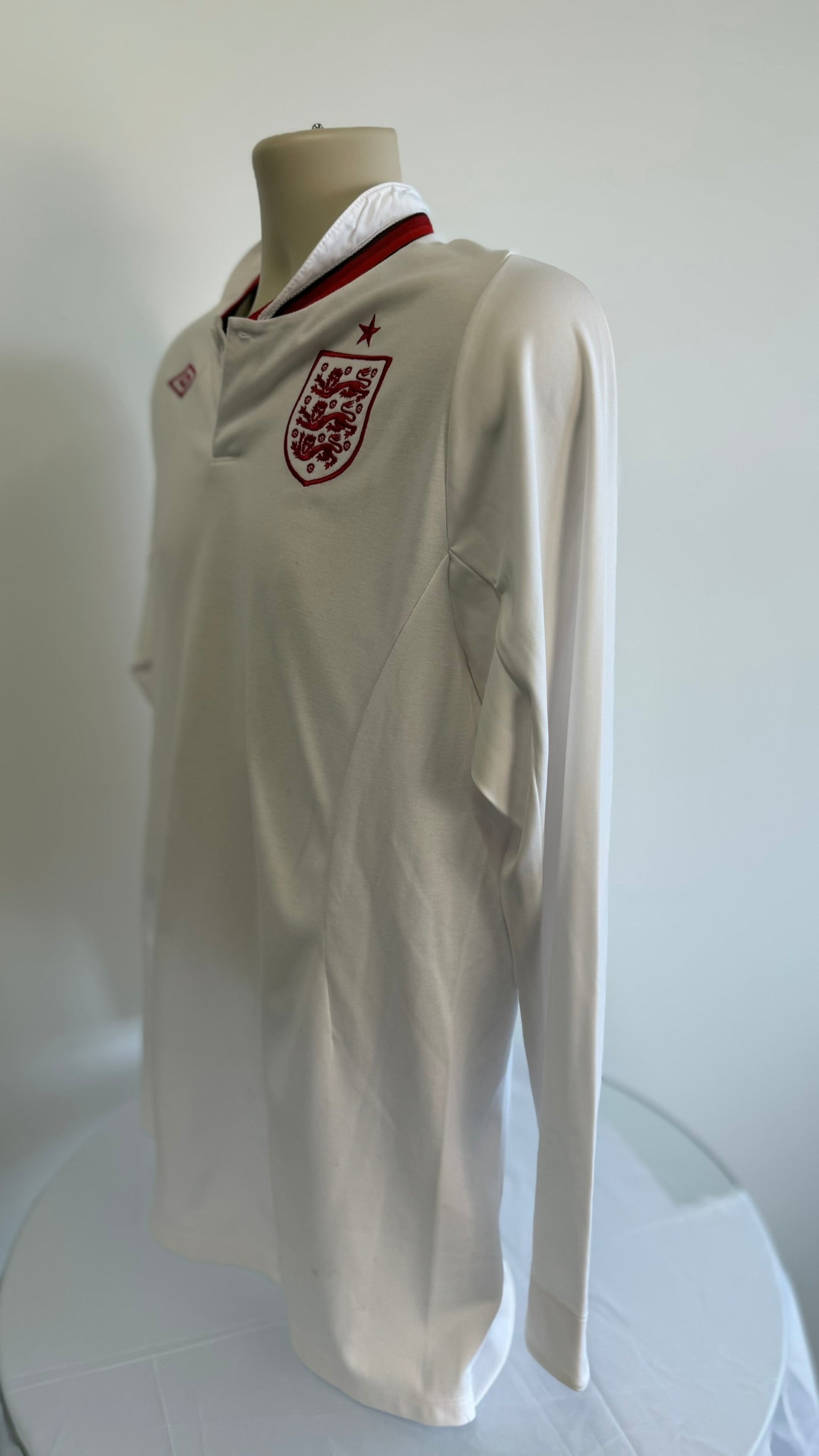 Angled side view of England white long sleeve football shirt with crest