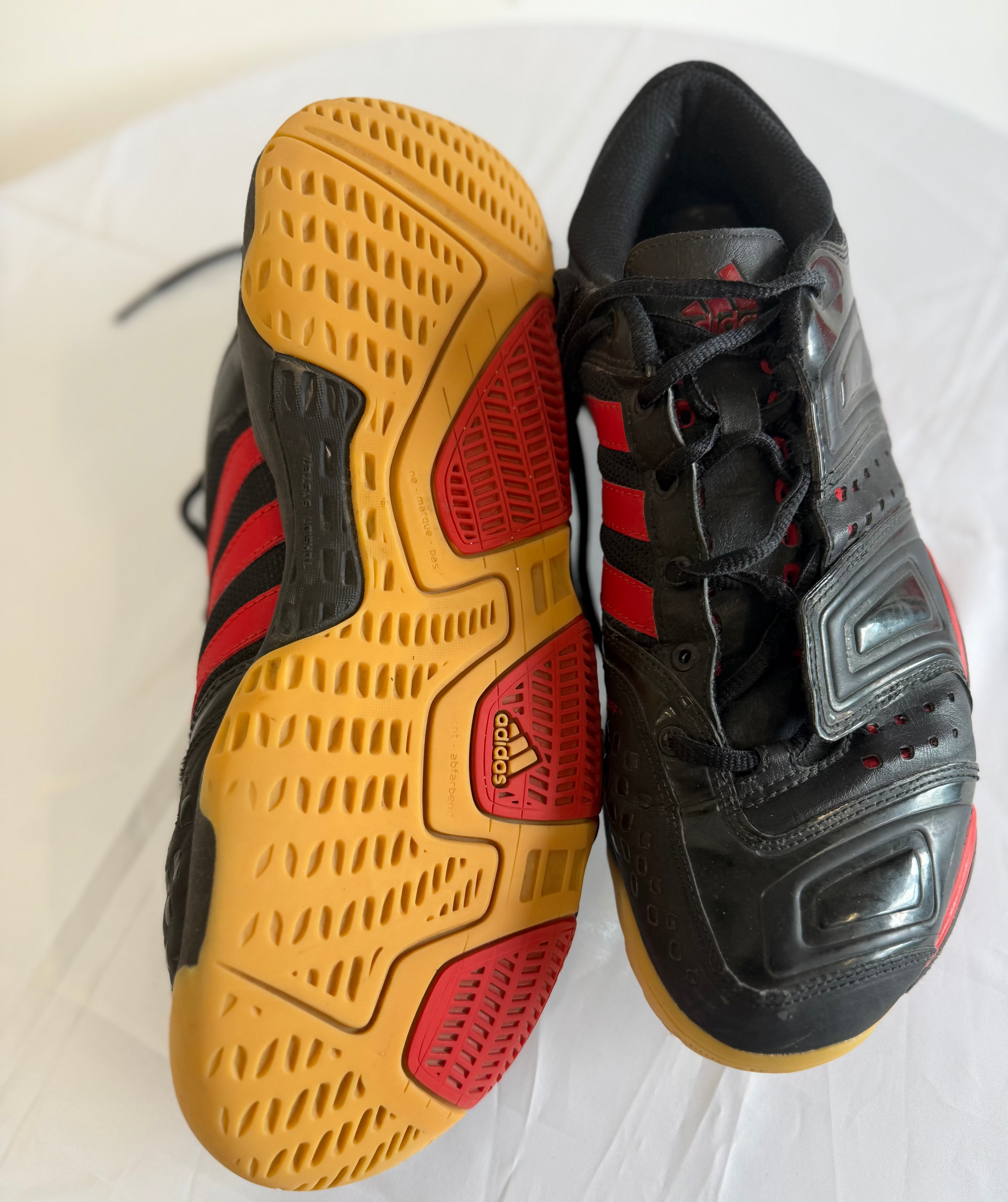 Adidas indoor court shoes showing gum outsole and tread pattern