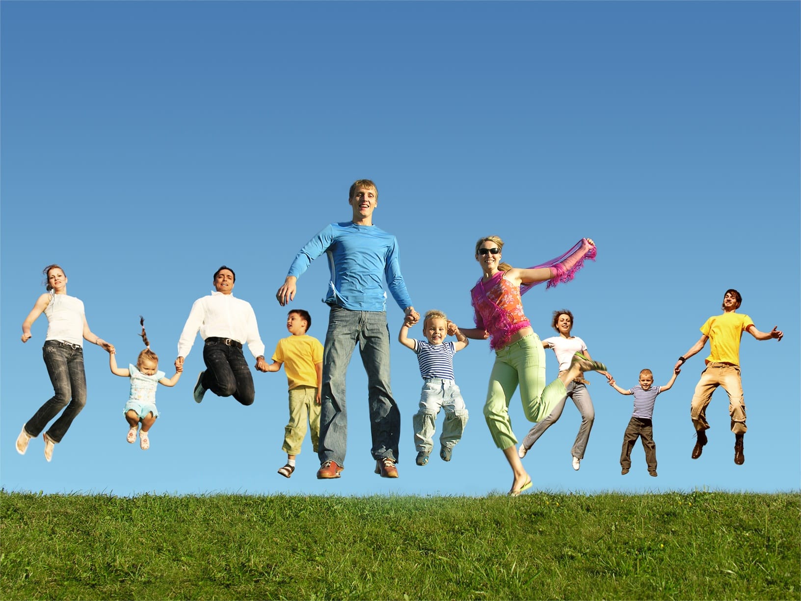 A group of people holding hands and jumping in a field