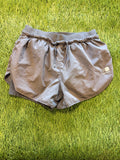Front view of grey Karrimor running shorts with elastic waistband and drawstring, laid flat on grass