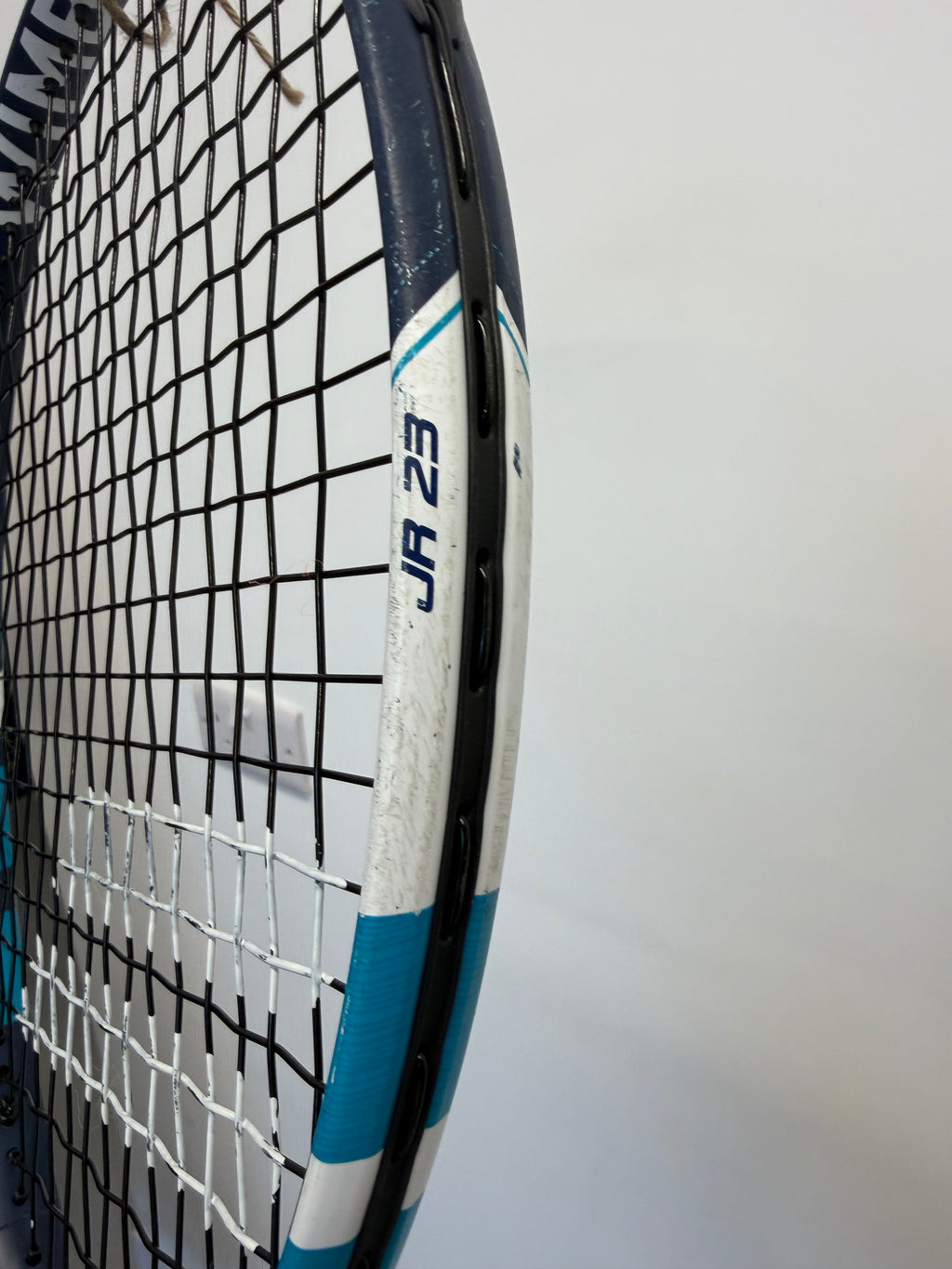 Babolat JR 23 marking and black stringing on blue and white tennis racket head