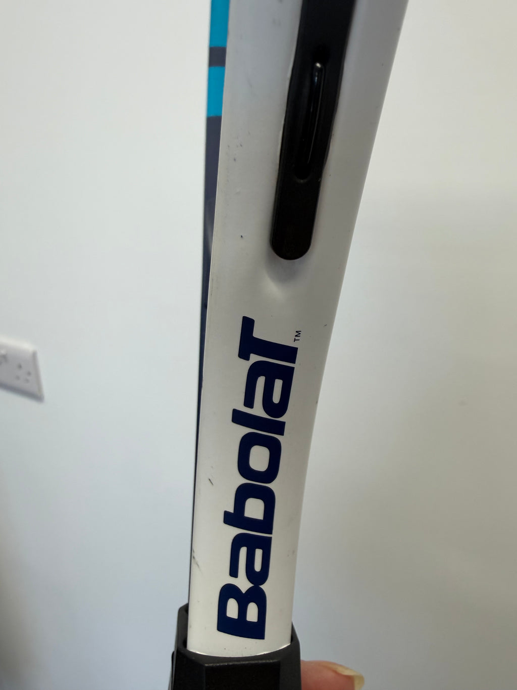 Close-up of Babolat branding on tennis racket shaft