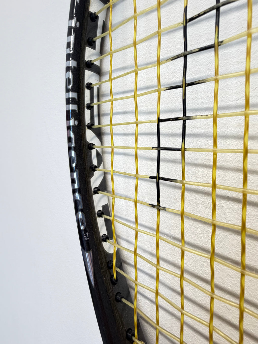 Detail of yellow and black stringing on Head i.Tour tennis racket