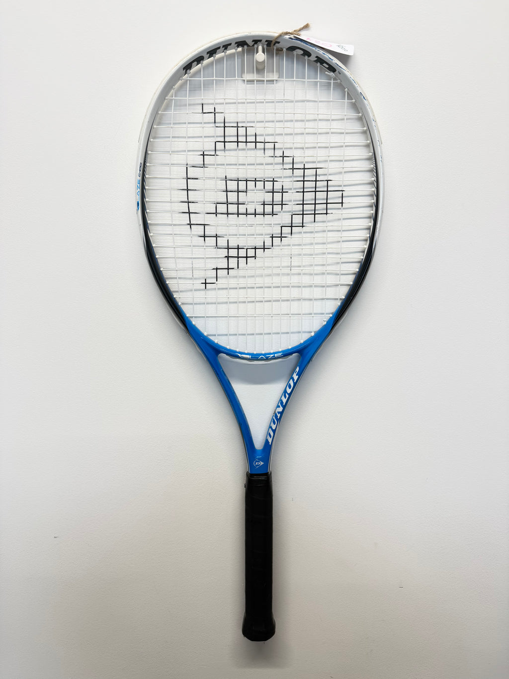 Full view of Dunlop Blaze C-100 tennis racket hanging on wall