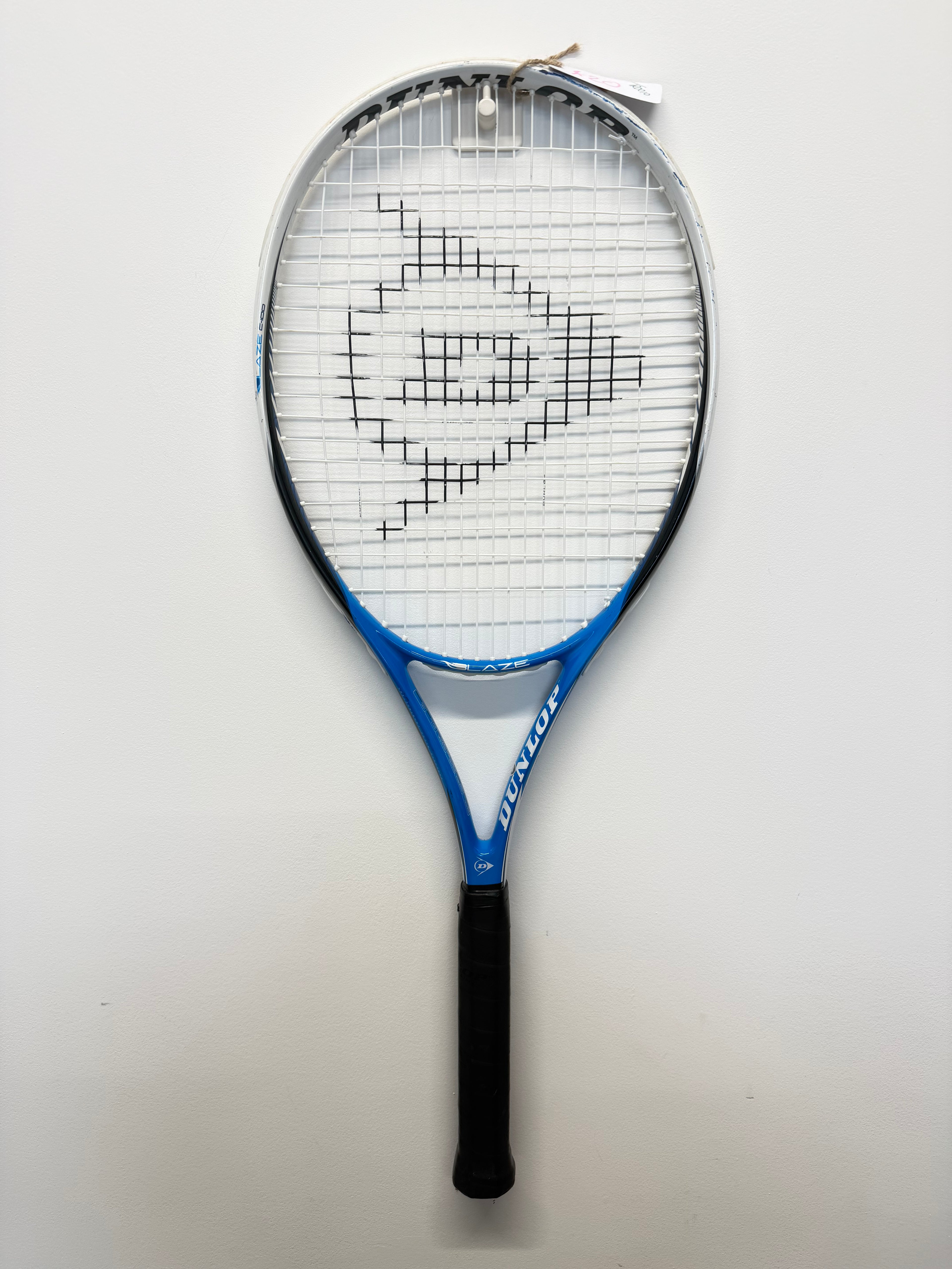 Full view of Dunlop Blaze C-100 tennis racket hanging on wall