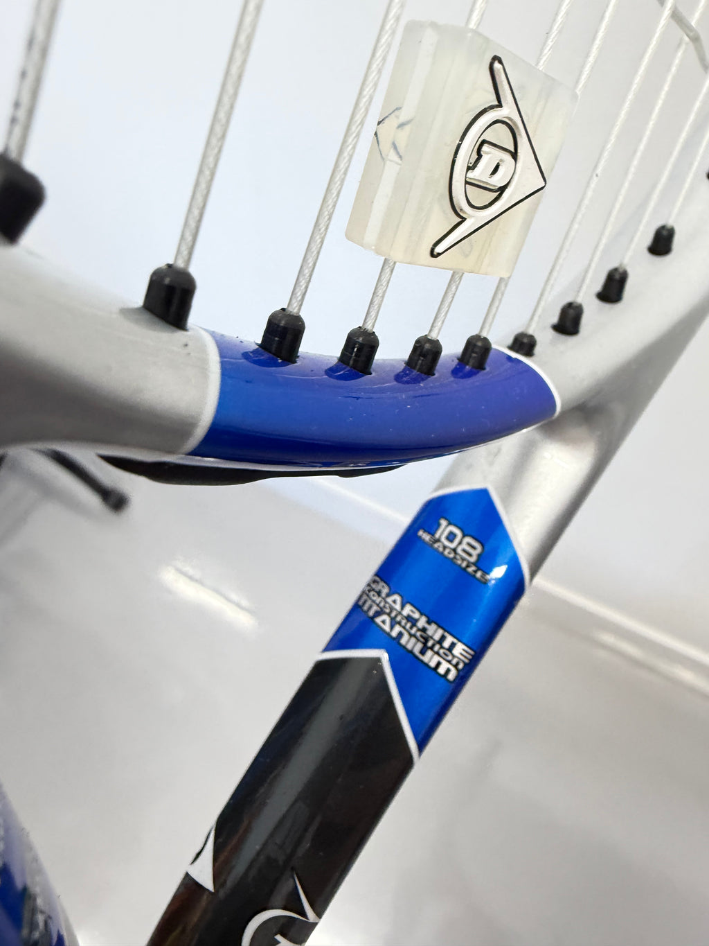 Detail of Dunlop logo and graphite titanium text on tennis racket
