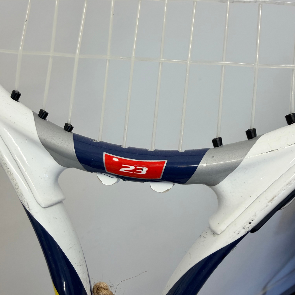 Close up of the throat and strings on a Wilson Steam 23 inch tennis racket in white, blue, yellow, and red