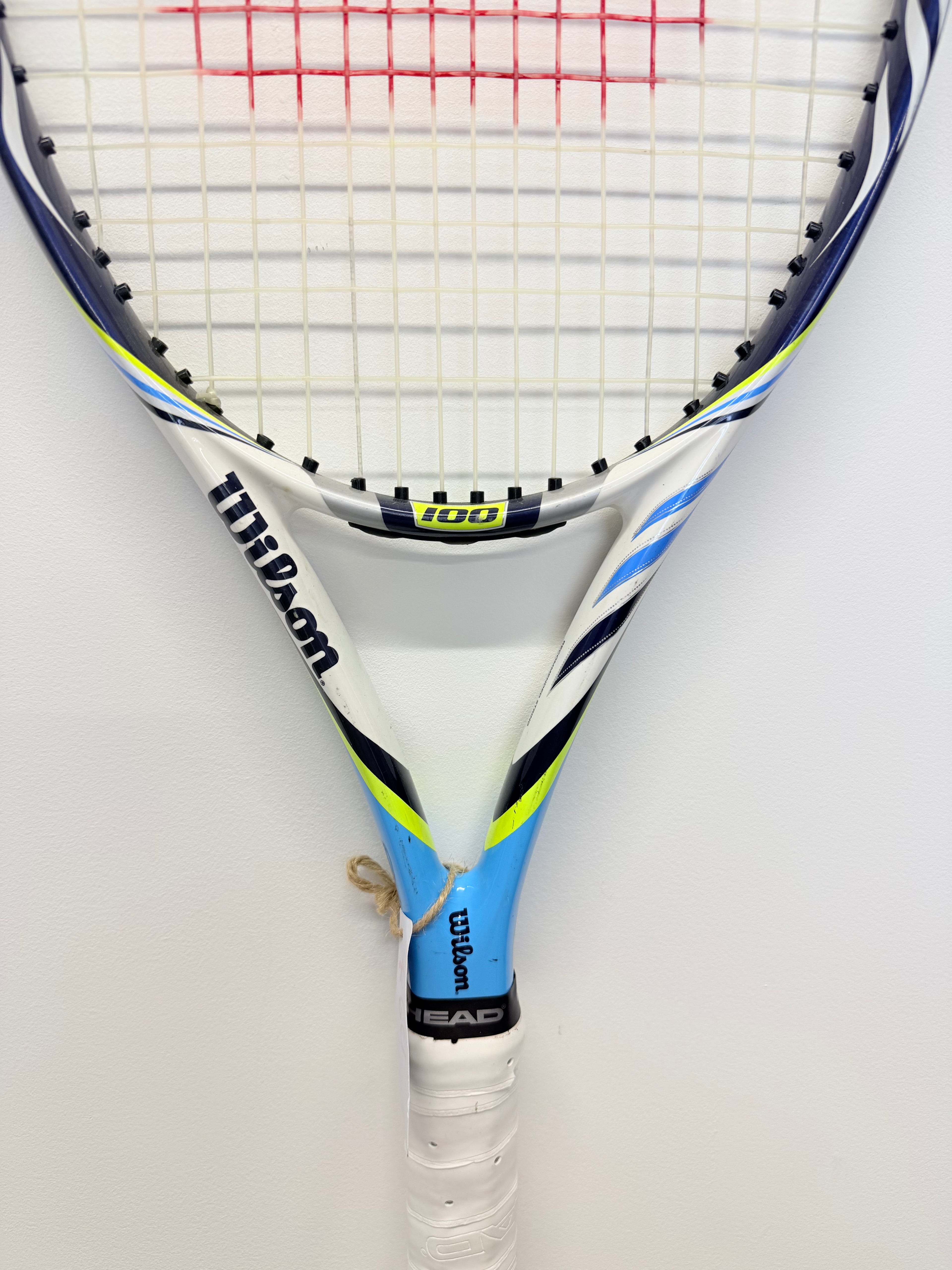 Partial front view of Wilson BLX tennis racket head and white grip