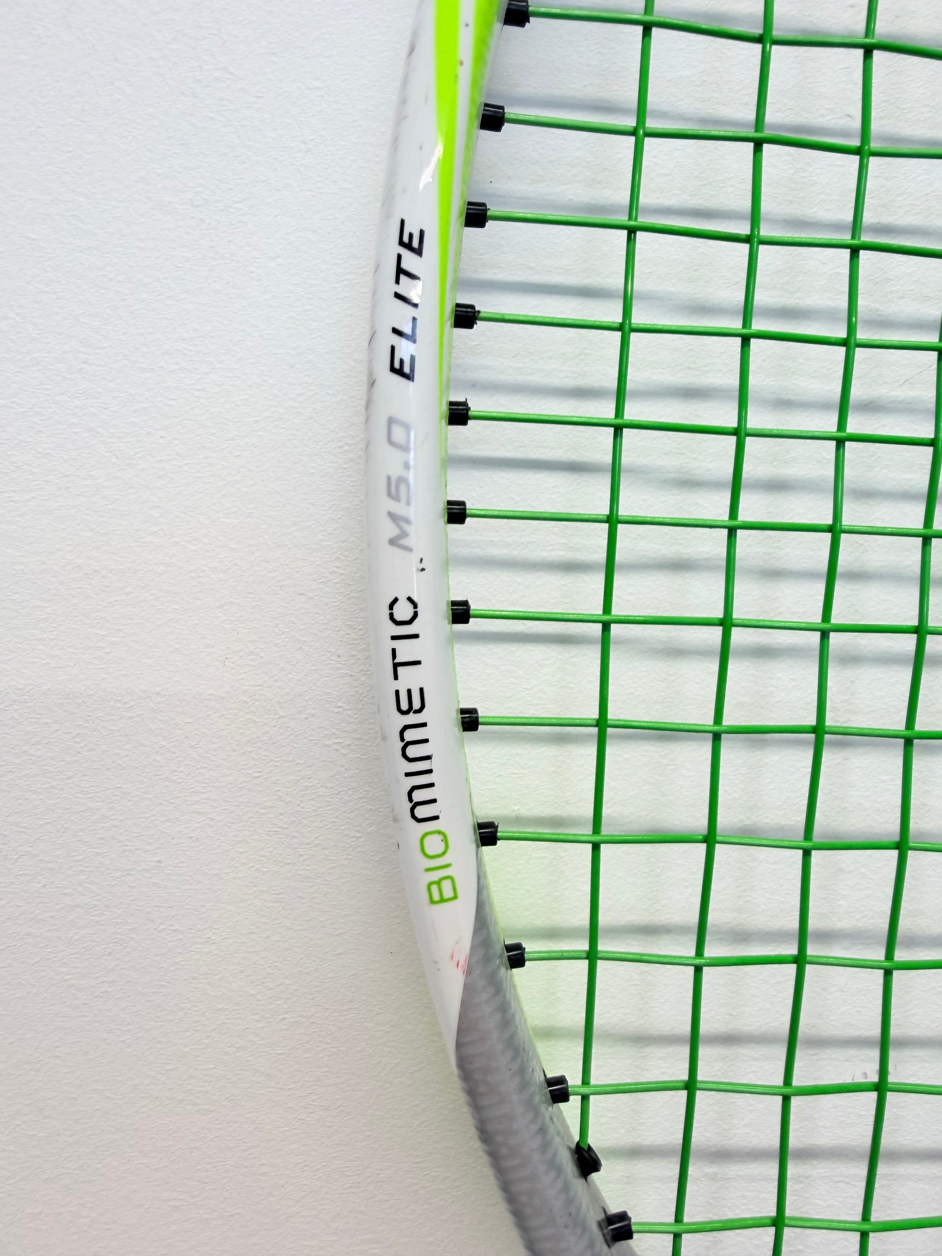 Detail of racket frame with Biomimetic M5.0 Elite text and green strings