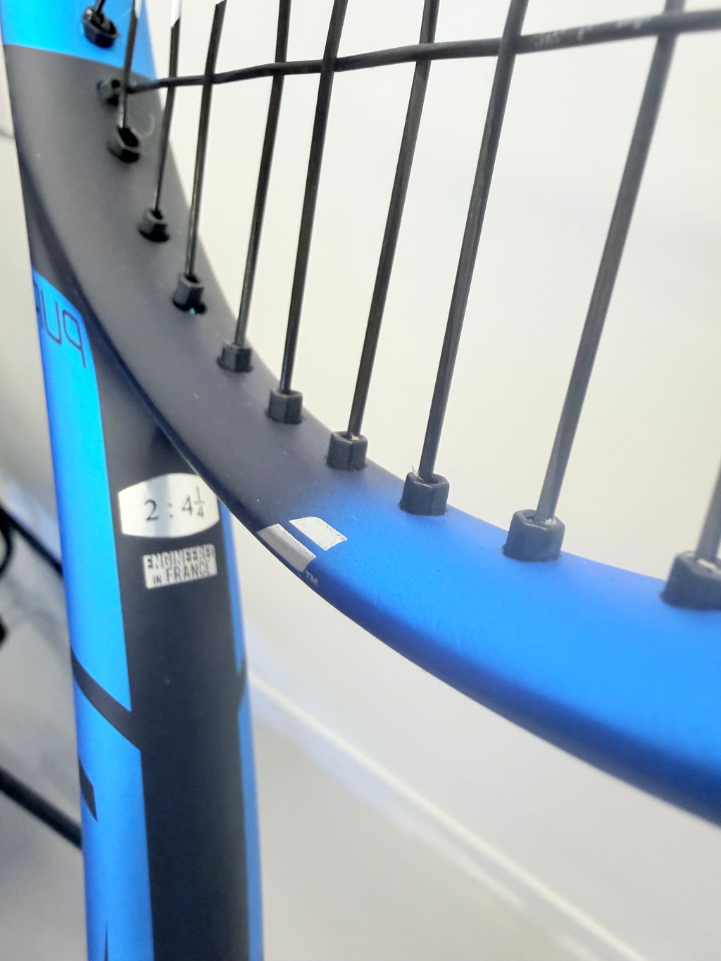 Macro image of Babolat Drive Lite blue frame and black string pattern