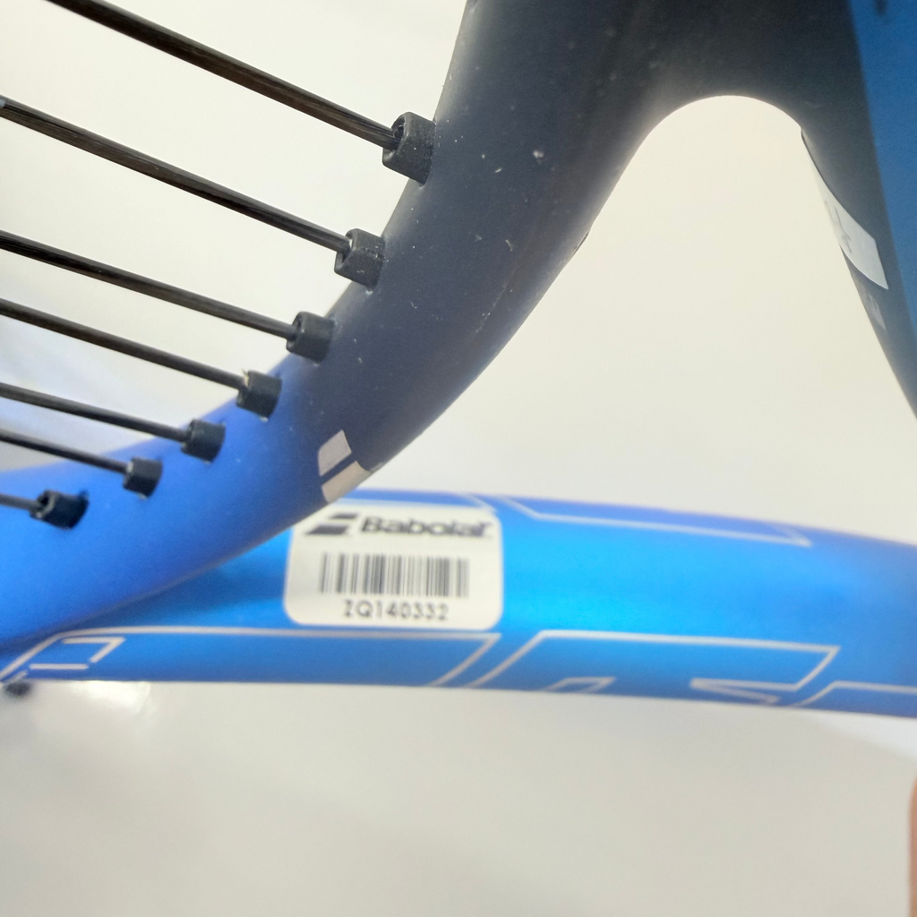 Detail of Babolat Drive Lite tennis racket with barcode and string pattern