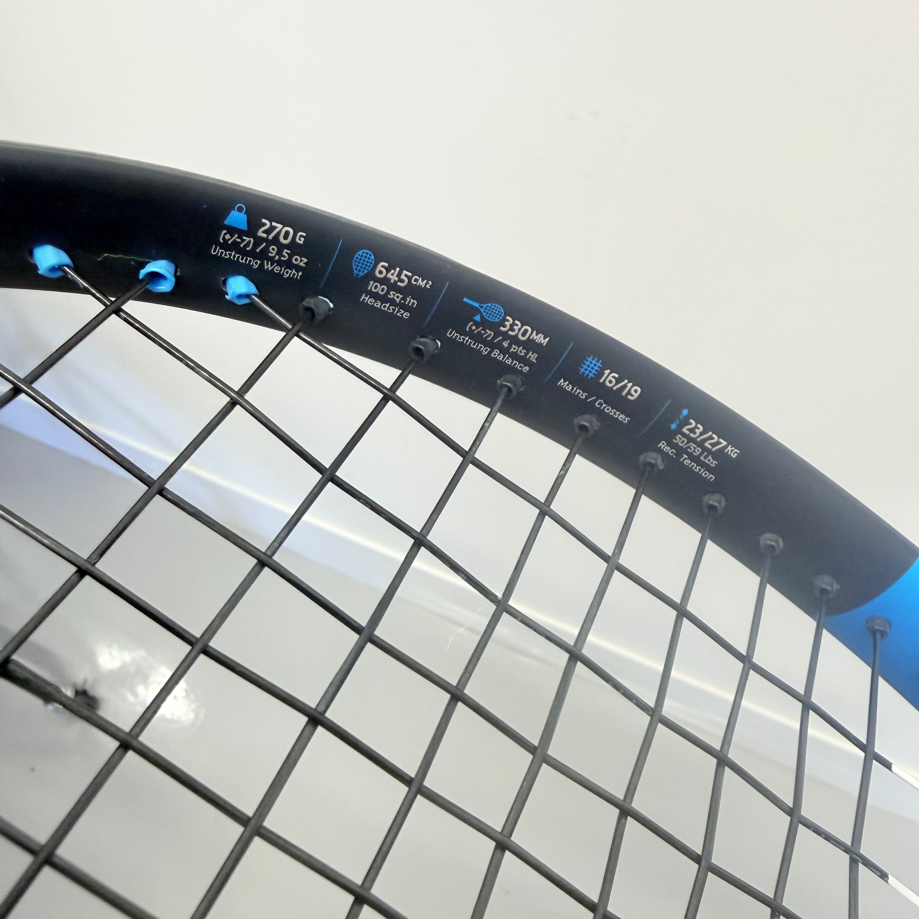 Close-up of Babolat Drive Lite tennis racket specifications on blue frame