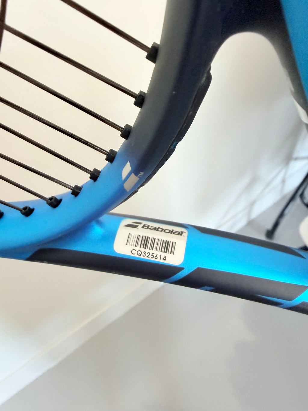 Babolat logo and barcode label on blue tennis racket frame