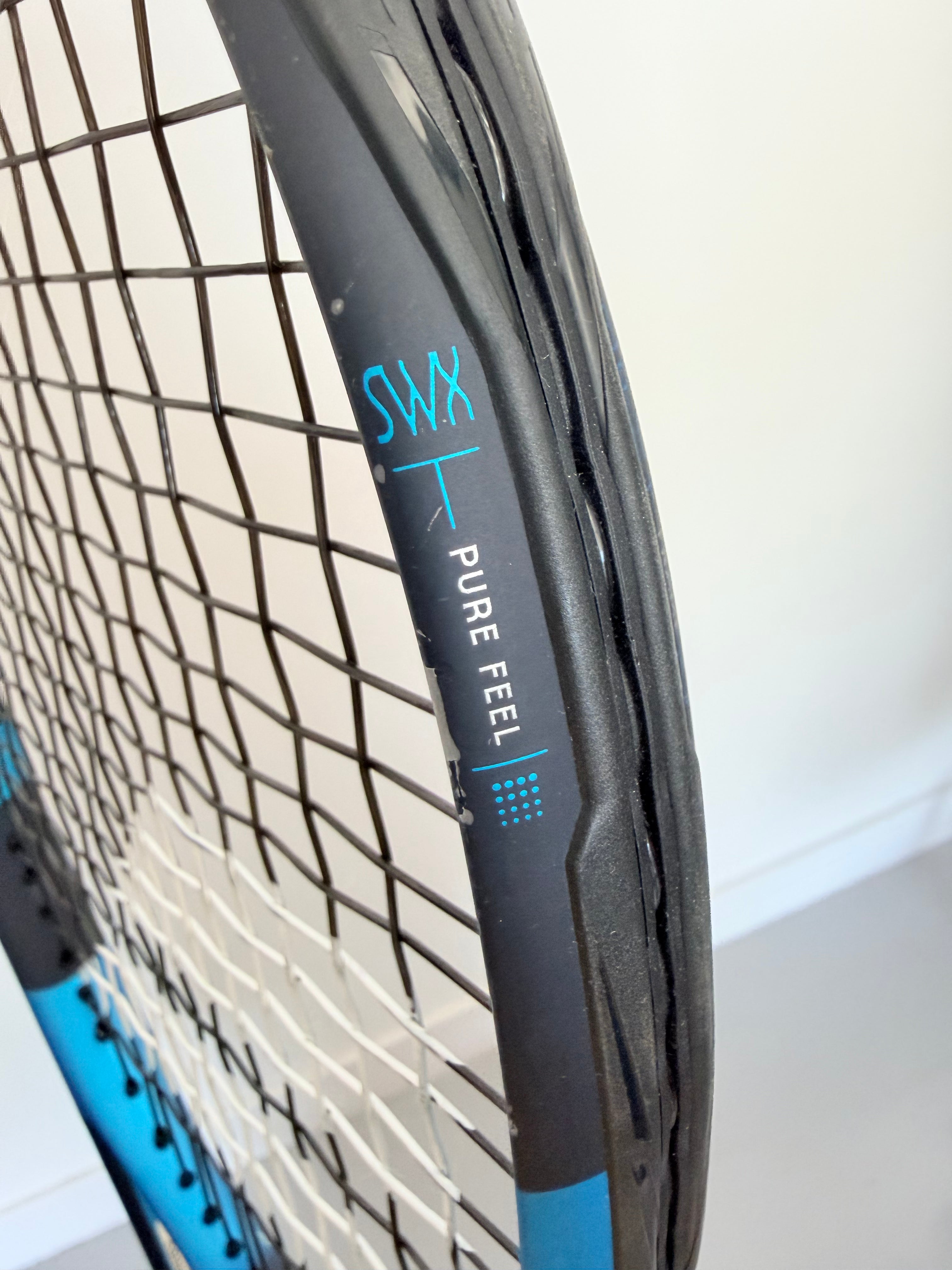 Close-up of Babolat Pure Feel technology label on tennis racket frame