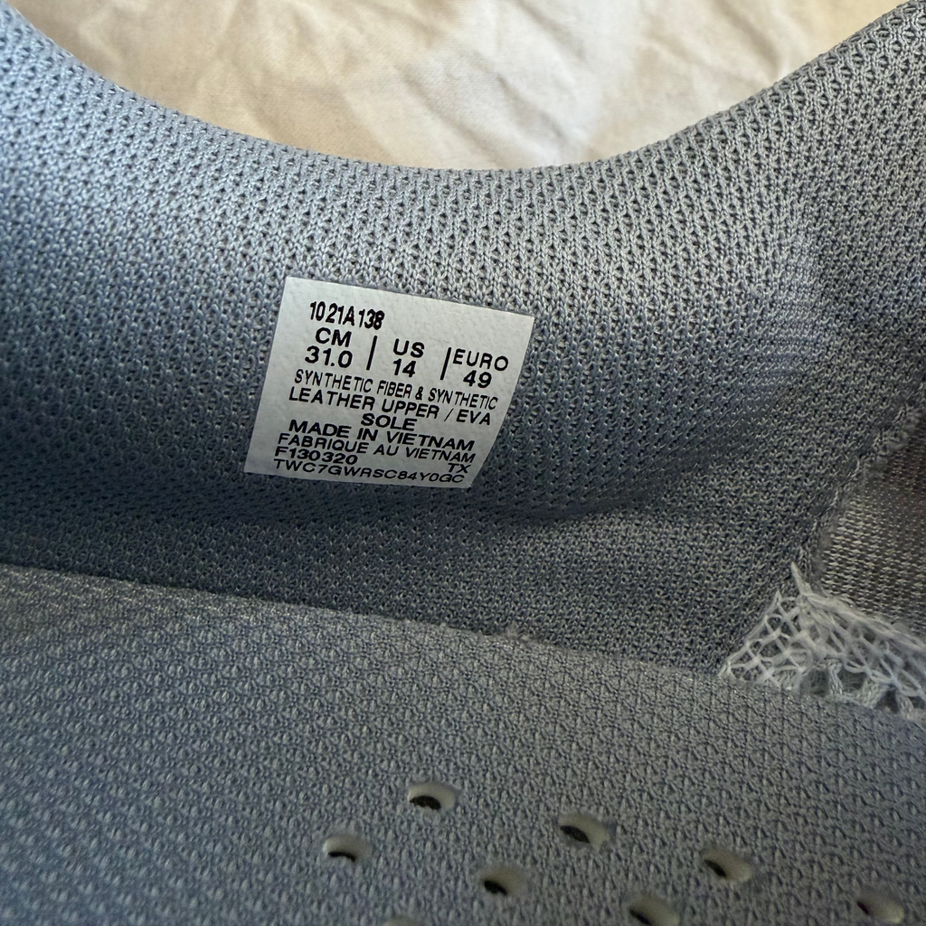Product label detail with size, materials, and manufacturing info in ASICS trainer