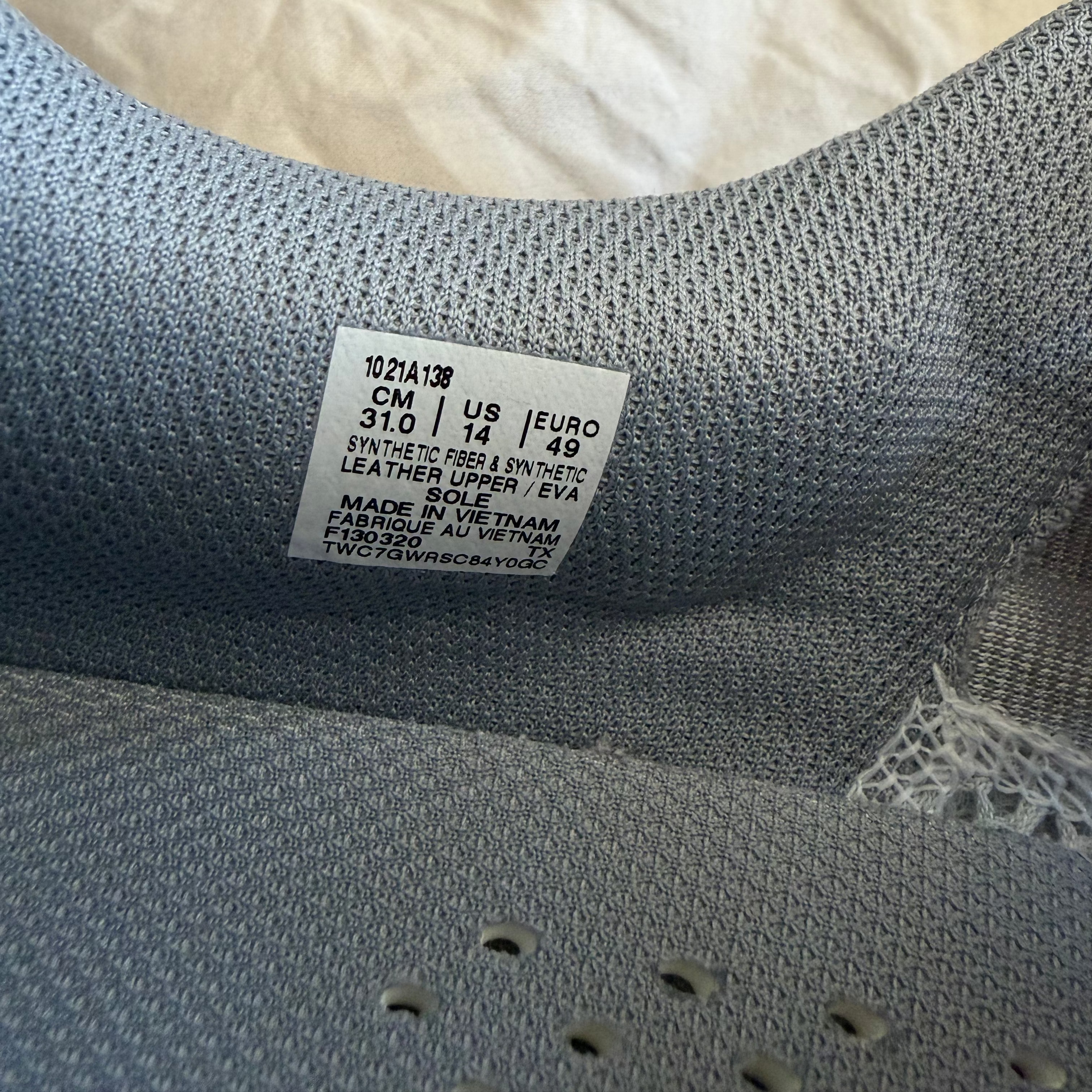 Product label detail with size, materials, and manufacturing info in ASICS trainer