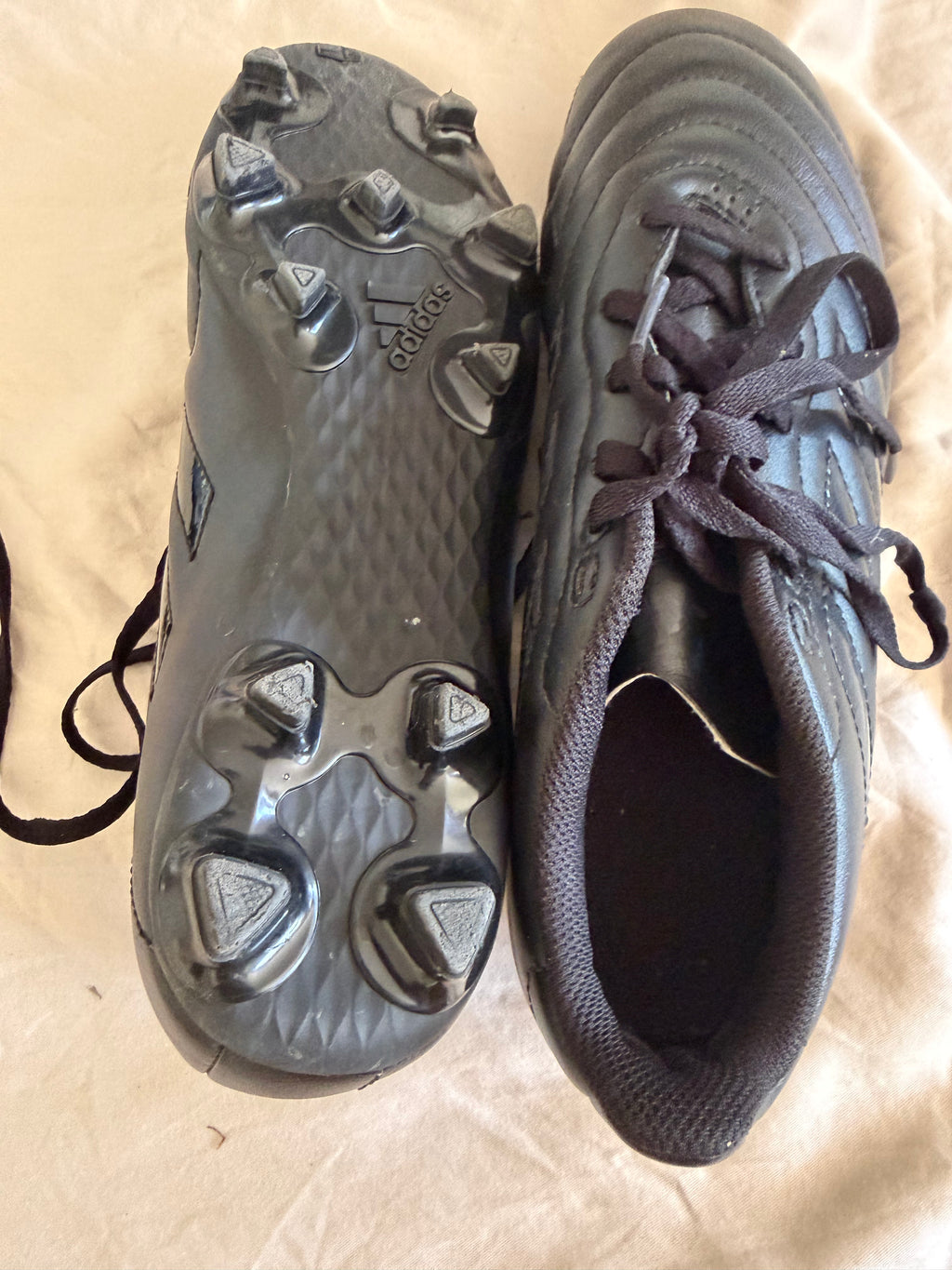 Black adidas football boots side and sole view