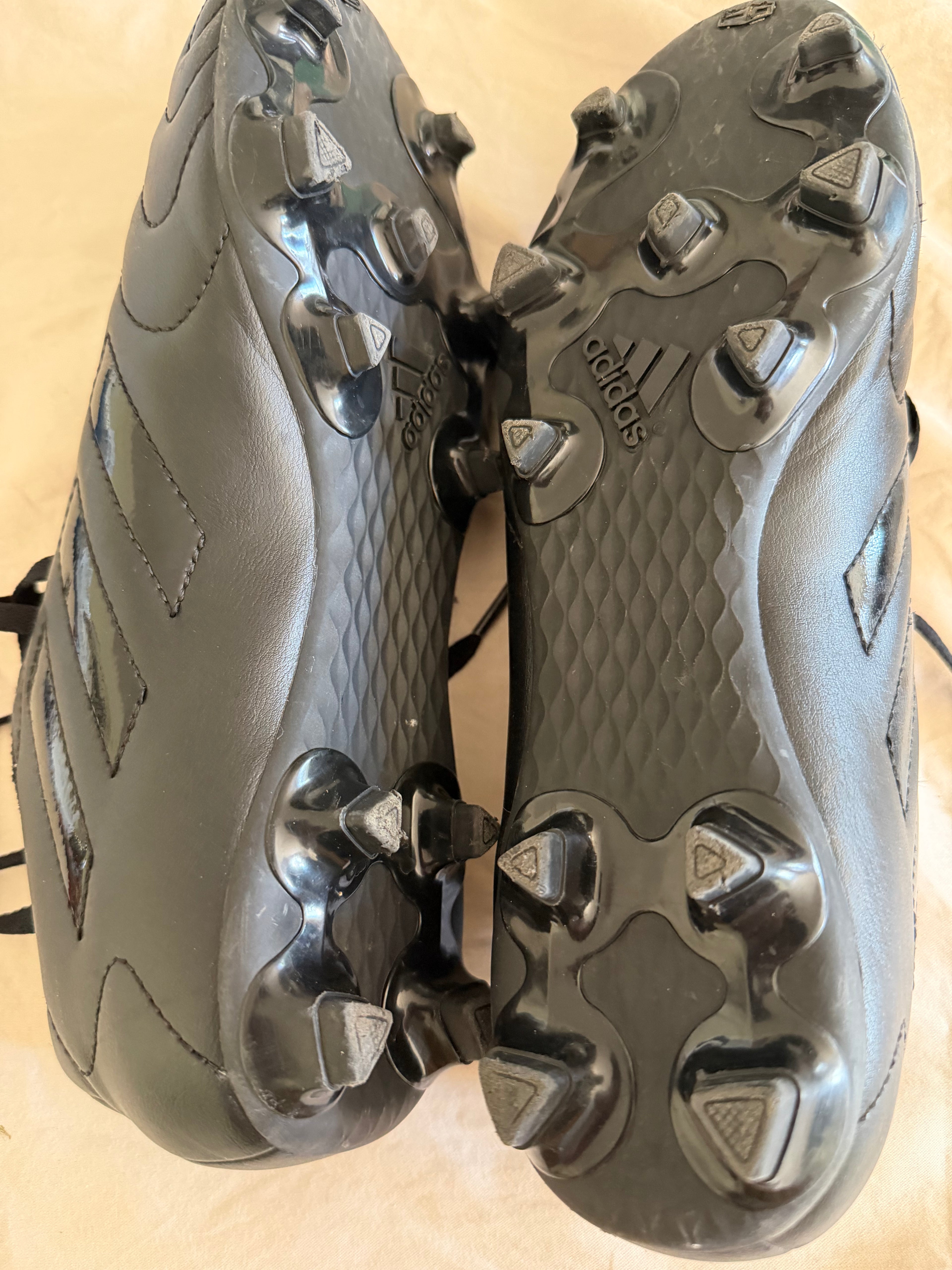 Black adidas football boots soles with moulded studs
